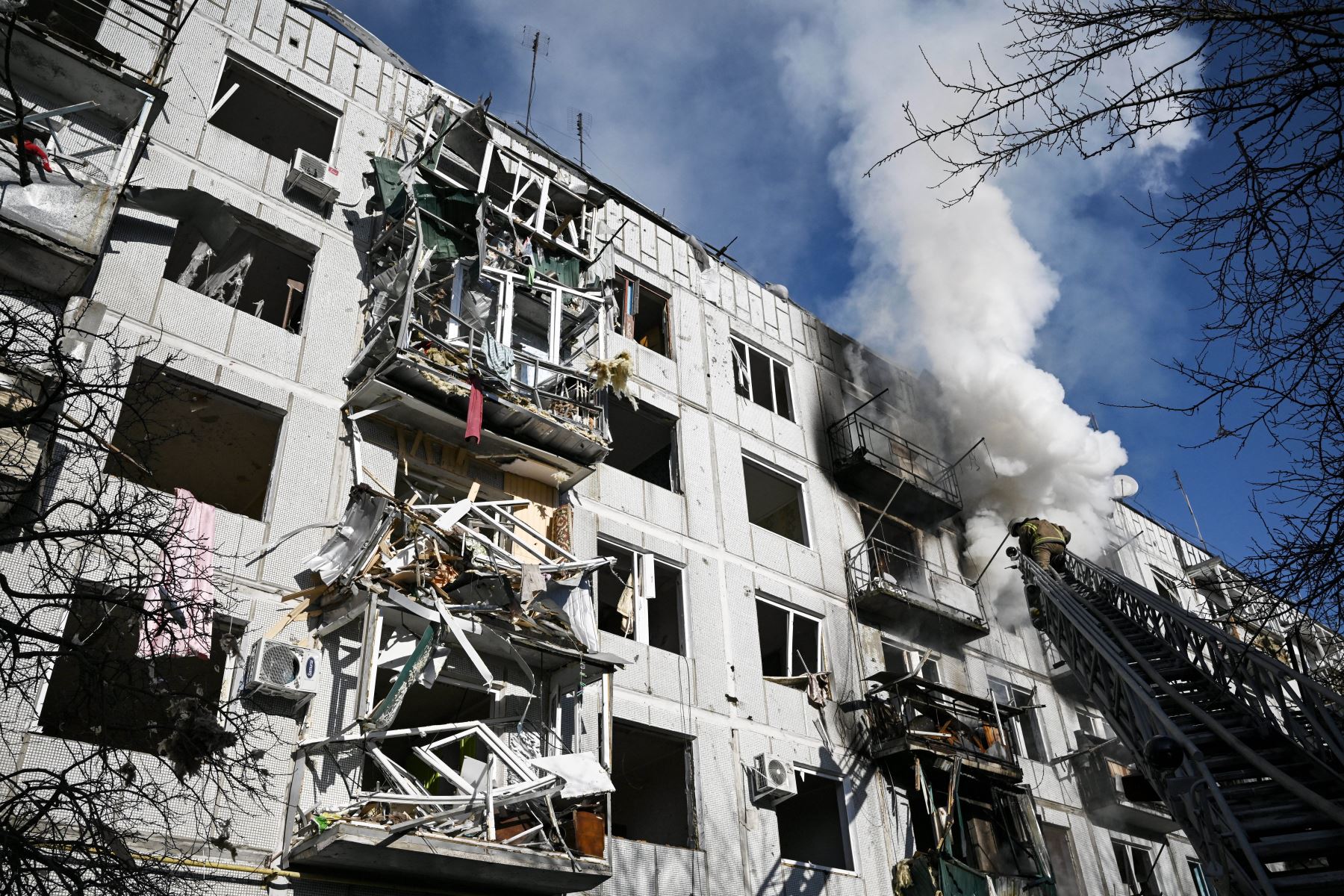 Bomberos trabajan en un incendio en un edificio después de los bombardeos en la ciudad de Chuguiv, en el este de Ucrania. Foto: AFP