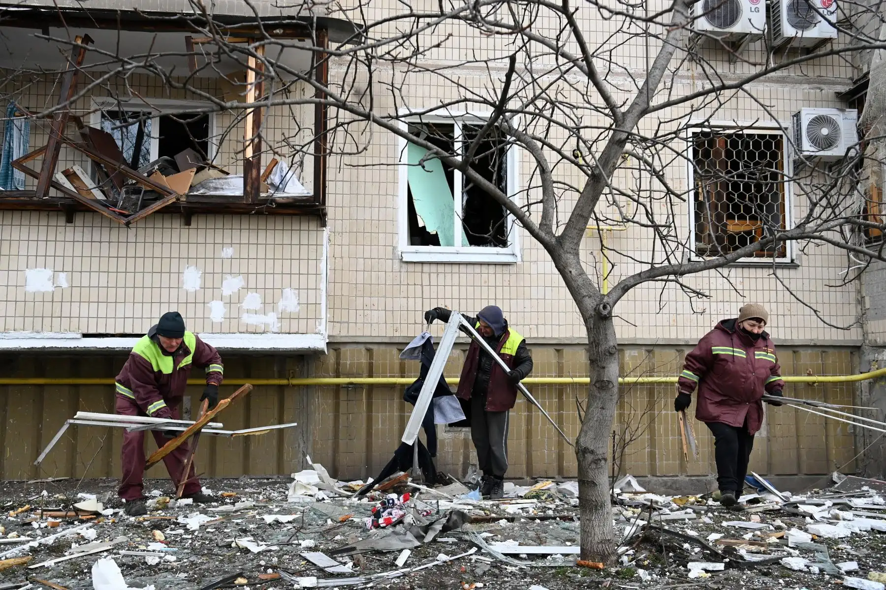 Un hombre limpia los escombros en un edificio residencial dañado en la calle Koshytsa, un suburbio de la capital ucraniana, Kiev, donde supuestamente cayó un proyectil militar. Foto: AFP