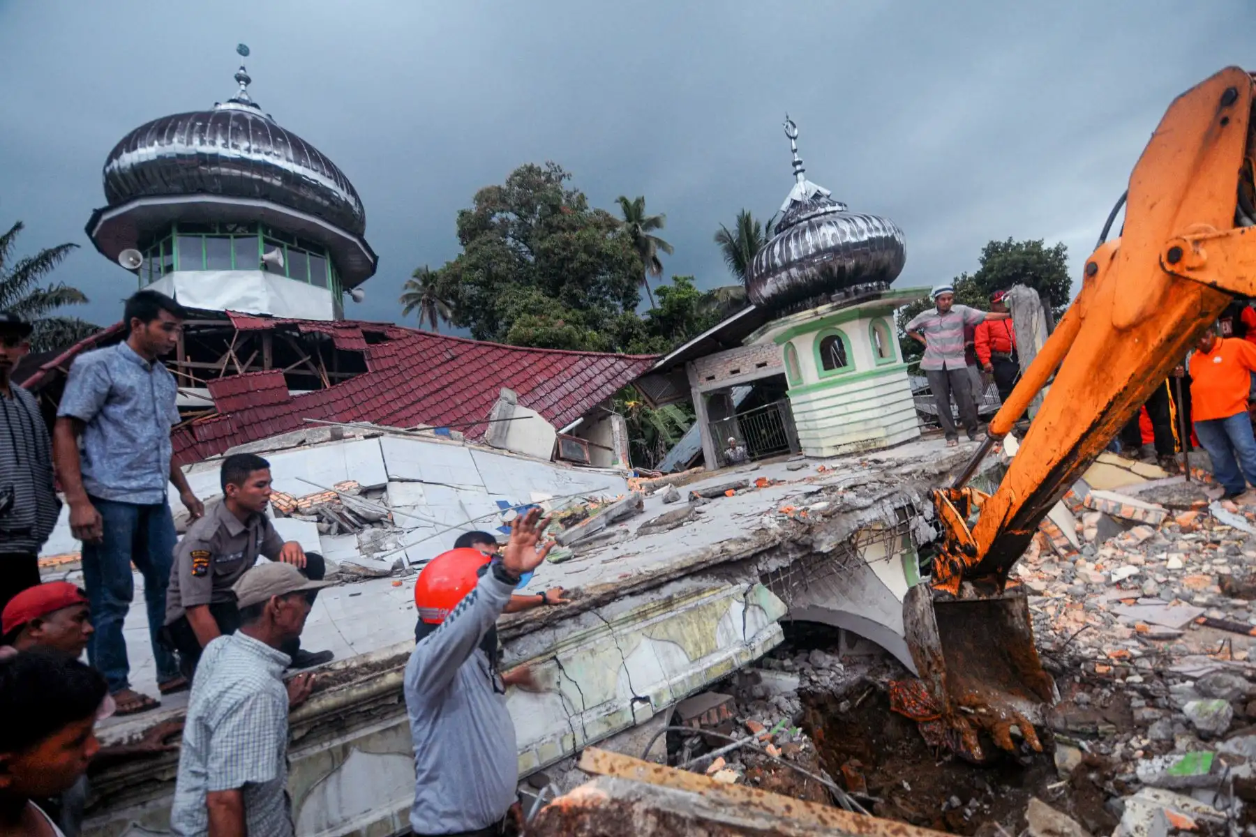 Equipos de rescate y los aldeanos usan equipo pesado en un esfuerzo por evacuar a las víctimas de los escombros de una mezquita, en West Pasaman, en Indonesia. Foto: AFP
