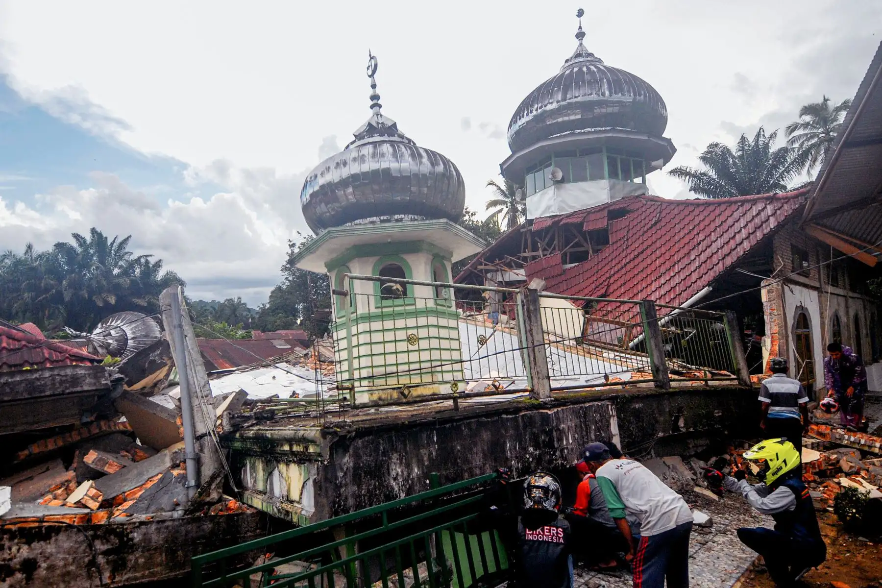 Equipos de rescate y los aldeanos usan equipo pesado en un esfuerzo por evacuar a las víctimas de los escombros de una mezquita, en West Pasaman, en Indonesia. Foto: AFP