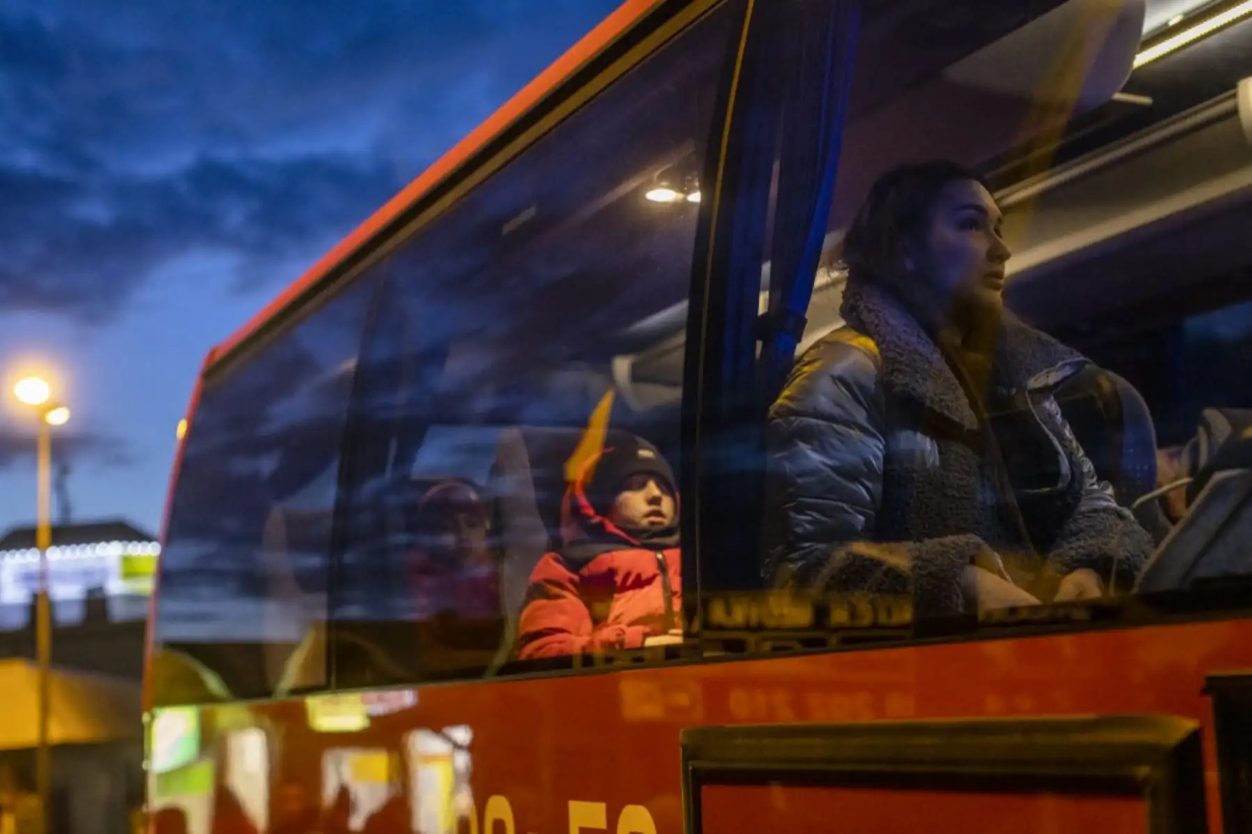 Ciudadanos ucranianos en un autobús en el cruce fronterizo de Medyka, este de Polonia, huyen del conflicto en su país, un día después de que Rusia lanzara un ataque militar contra su vecina Ucrania. Foto: AFP