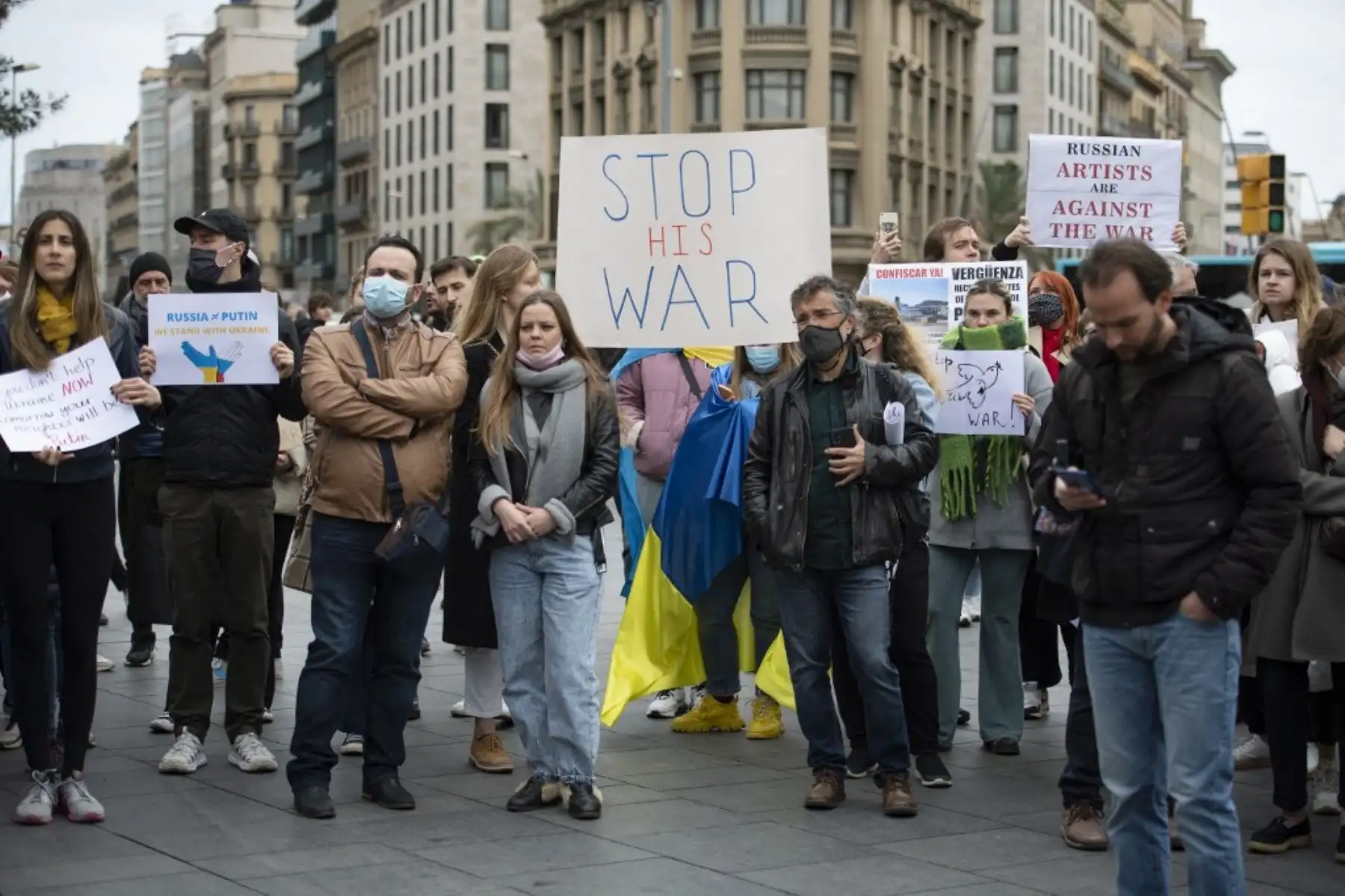 manifestantes sostienen carteles durante una protesta contra la operación militar de Rusia en Ucrania, en Barcelona el 26 de febrero de 2022. Foto: AFP