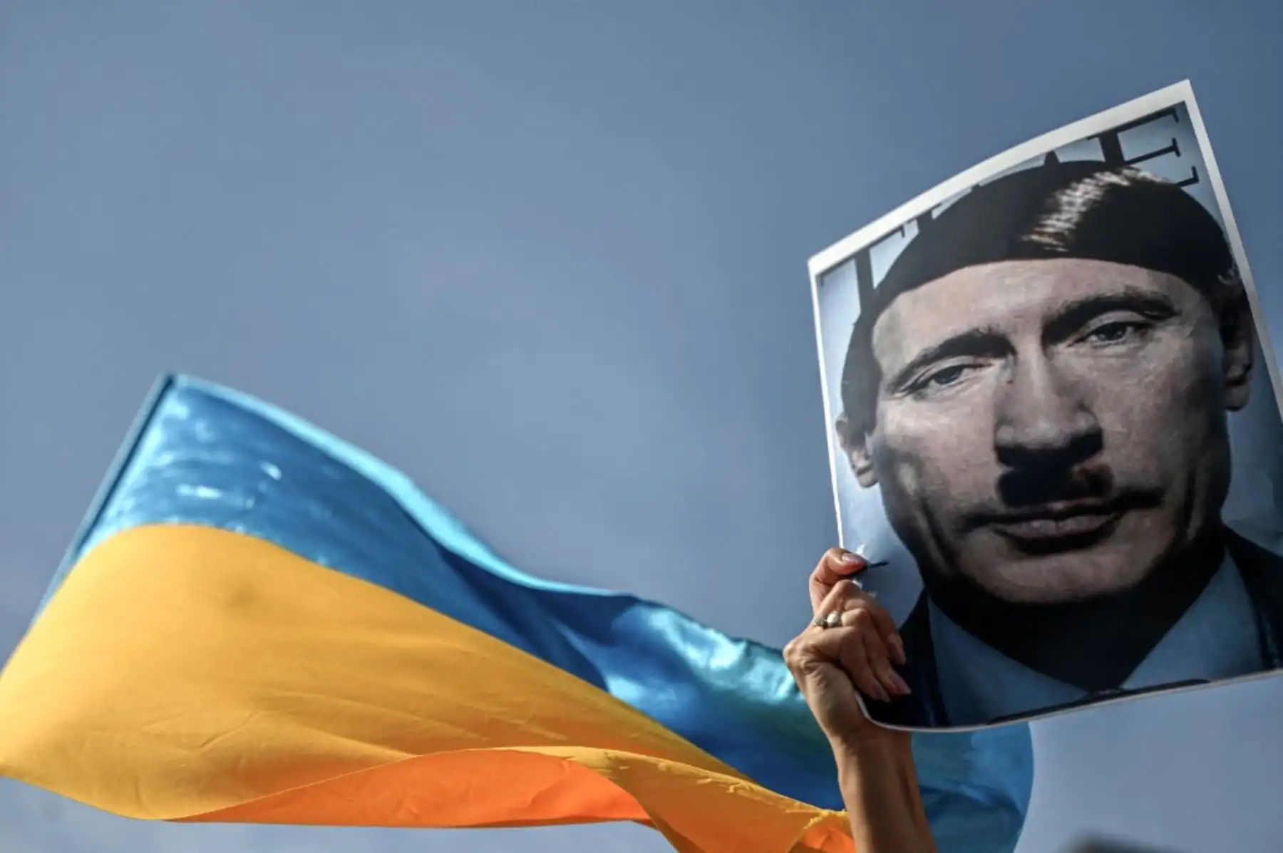 Un manifestante sostiene una imagen que muestra al presidente ruso Vladimir Putin como Adolf Hitler durante una manifestación contra la rusa de Ucrania en el distrito de Beyazid en Estambul, el 26 de febrero de 2022. Foto: AFP