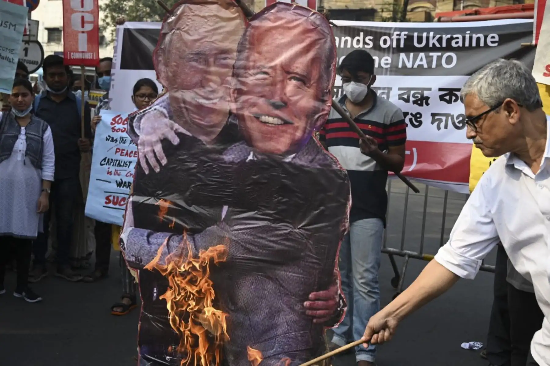 Activistas de izquierda del Centro de Unidad Socialista de India (comunista) o se preparan para quemar efigies del presidente ruso Vladimir Putin (izquierda) y el presidente estadounidense Joe Biden abrazándose mientras protestan contra la invasión rusa en Ucrania durante una manifestación en Calcuta el 26 de febrero de 2022. Foto: AFP