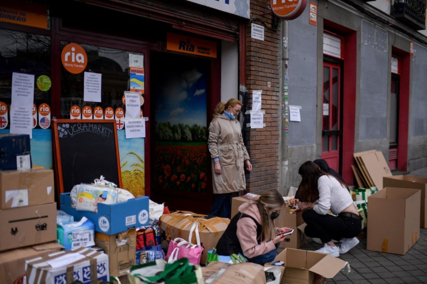 Los voluntarios empaquetan artículos esenciales donados como parte de una campaña de recolección para apoyar a los ciudadanos en Ucrania, frente a la tienda "Ukramarket" en Madrid. Foto: AFP