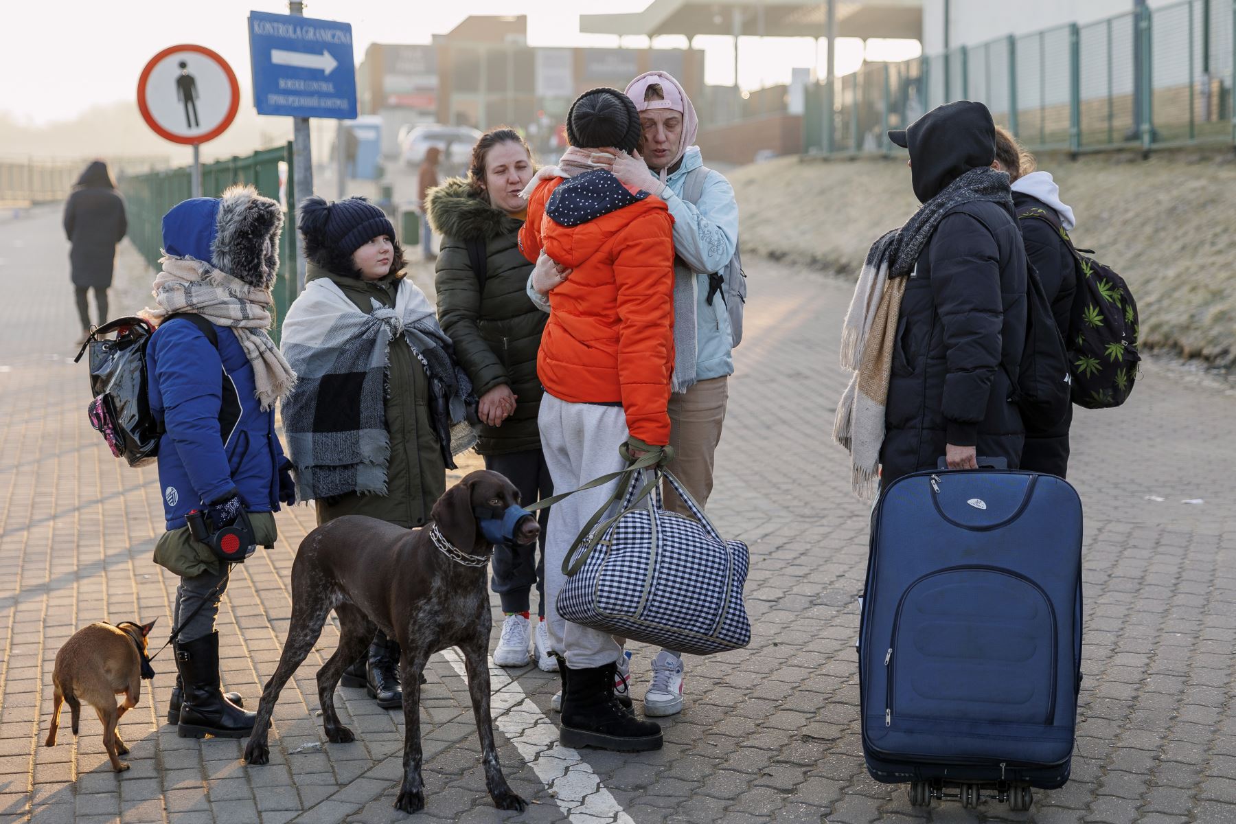 Dos personas procedentes de Ucrania se despiden tras cruzar la frontera con Polonia huyendo de la guerra. EFE / Biel Aliño