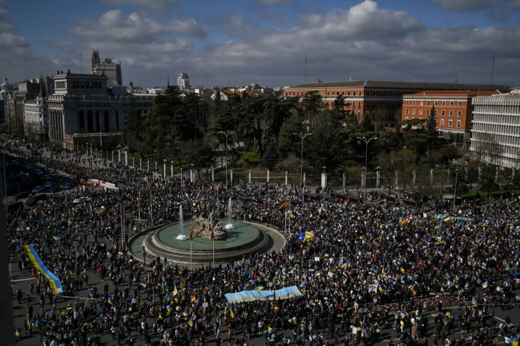 Manifestantes se reúnen y ondean banderas durante una protesta contra la invasión rusa de Ucrania en la Plaza de Cibeles en Madrid el 27 de febrero de 2022. Foto: AFP