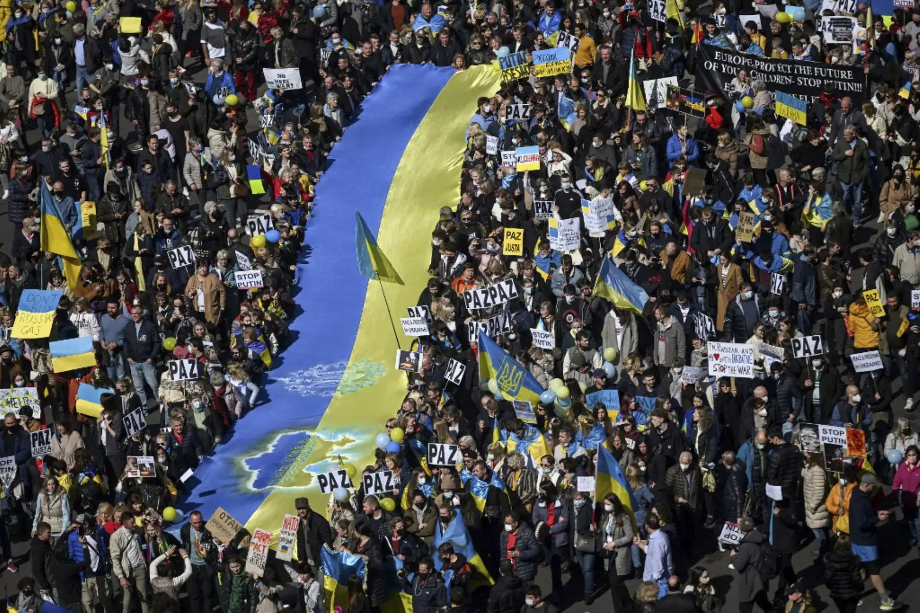 Manifestantes sostienen una bandera ucraniana gigante durante una protesta contra la invasión rusa de Ucrania en Madrid el 27 de febrero de 2022. Foto: AFP