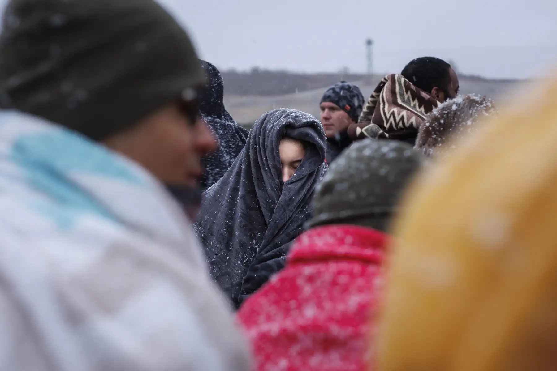 Varias personas procedentes de Ucrania esperan el autobús tras cruzar la frontera con Polonia huyendo de la guerra. Foto: EFE