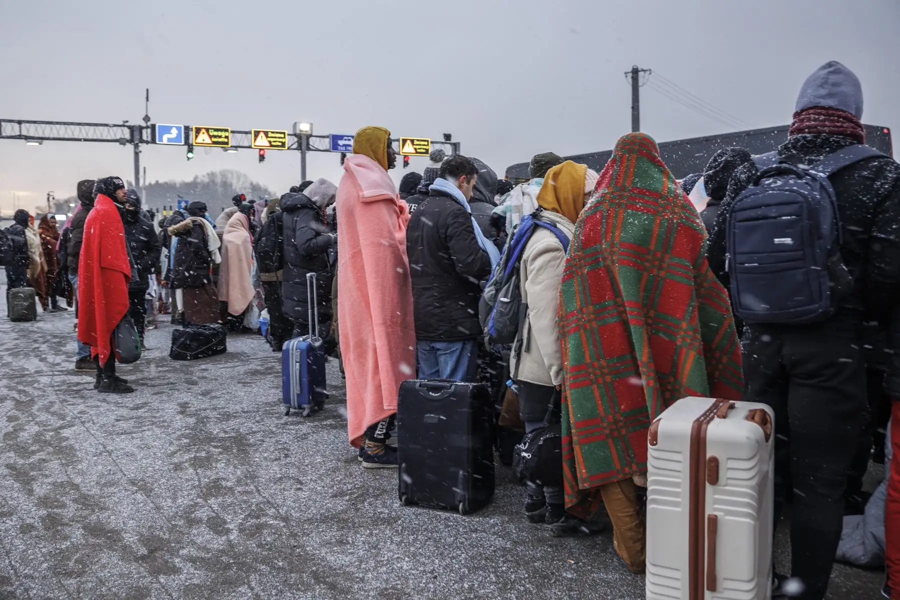 Varias personas procedentes de Ucrania esperan el autobús tras cruzan la frontera con Polonia huyendo de la guerra. Las delegaciones rusa y ucraniana comenzaron hoy las negociaciones en Pripiat, en la frontera ucraniano-bielorrusa, en las que Kiev intentará lograr un alto el fuego por parte de Rusia tras cinco días de guerra. Foto: EFE
