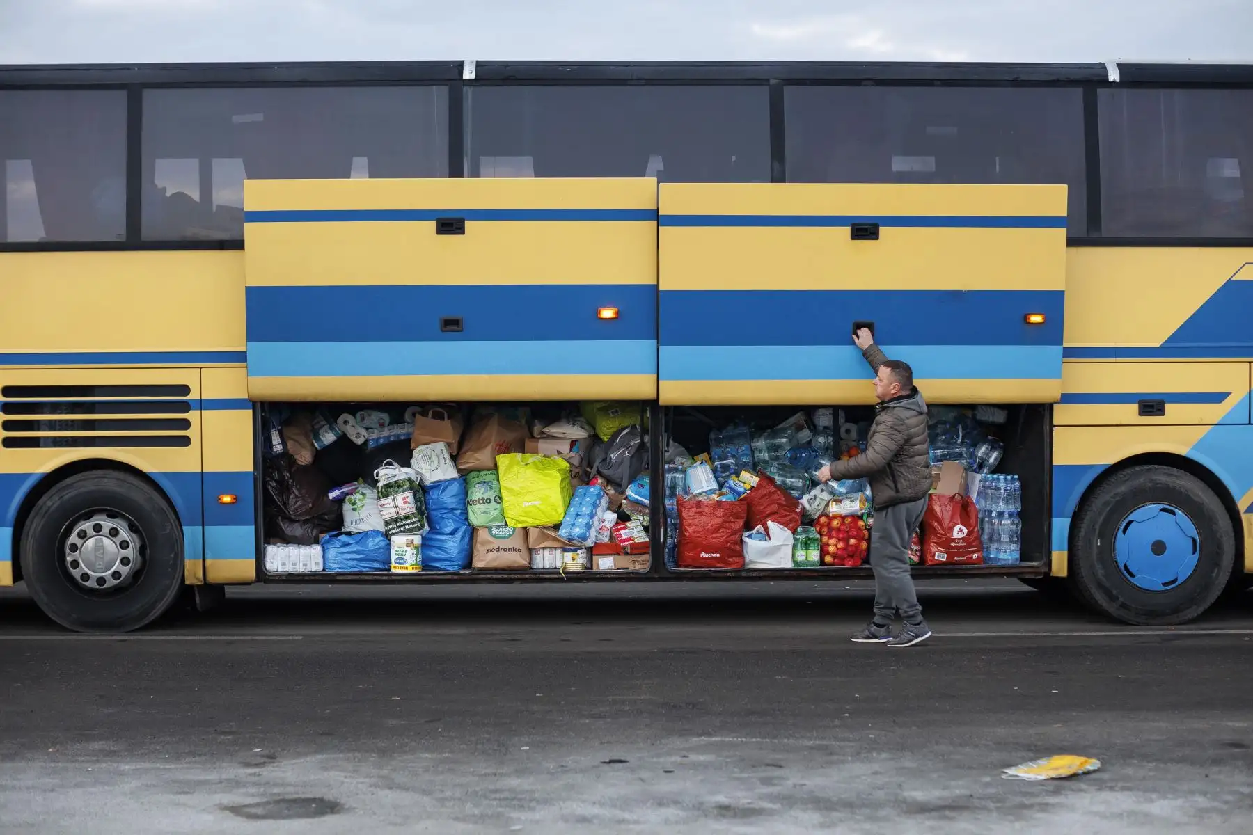 Varias personas procedentes de Ucrania esperan el autobús tras cruzan la frontera con Polonia huyendo de la guerra. Las delegaciones rusa y ucraniana comenzaron hoy las negociaciones en Pripiat, en la frontera ucraniano-bielorrusa, en las que Kiev intentará lograr un alto el fuego por parte de Rusia tras cinco días de guerra. Foto: EFE