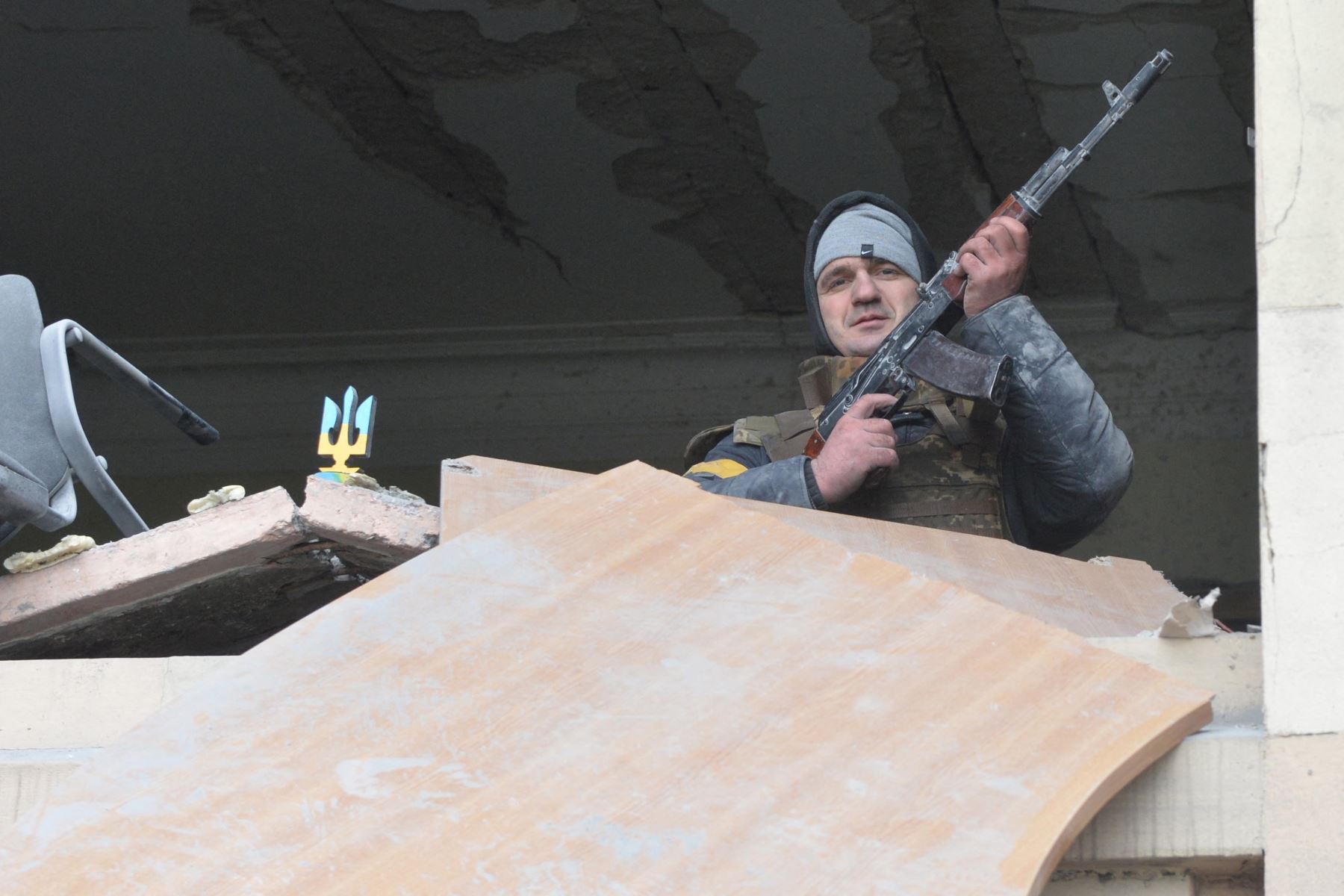 Hombre armado dentro del ayuntamiento local dañado de Kharkiv, destruido como resultado del bombardeo de las tropas rusas. Foto: AFP