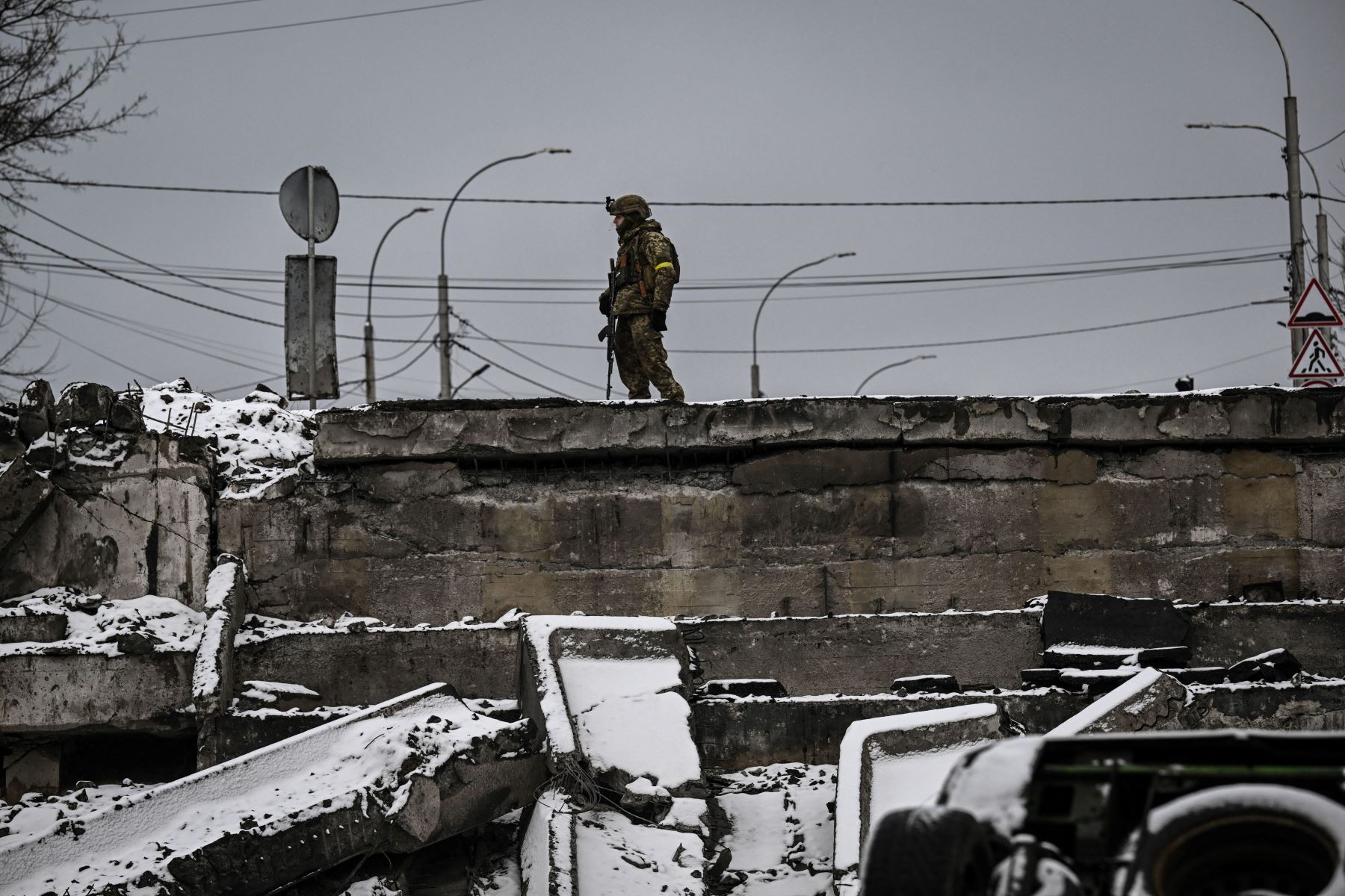 Un soldado ucraniano protege un puente volado en el frente norte de Kiev. Foto: AFP