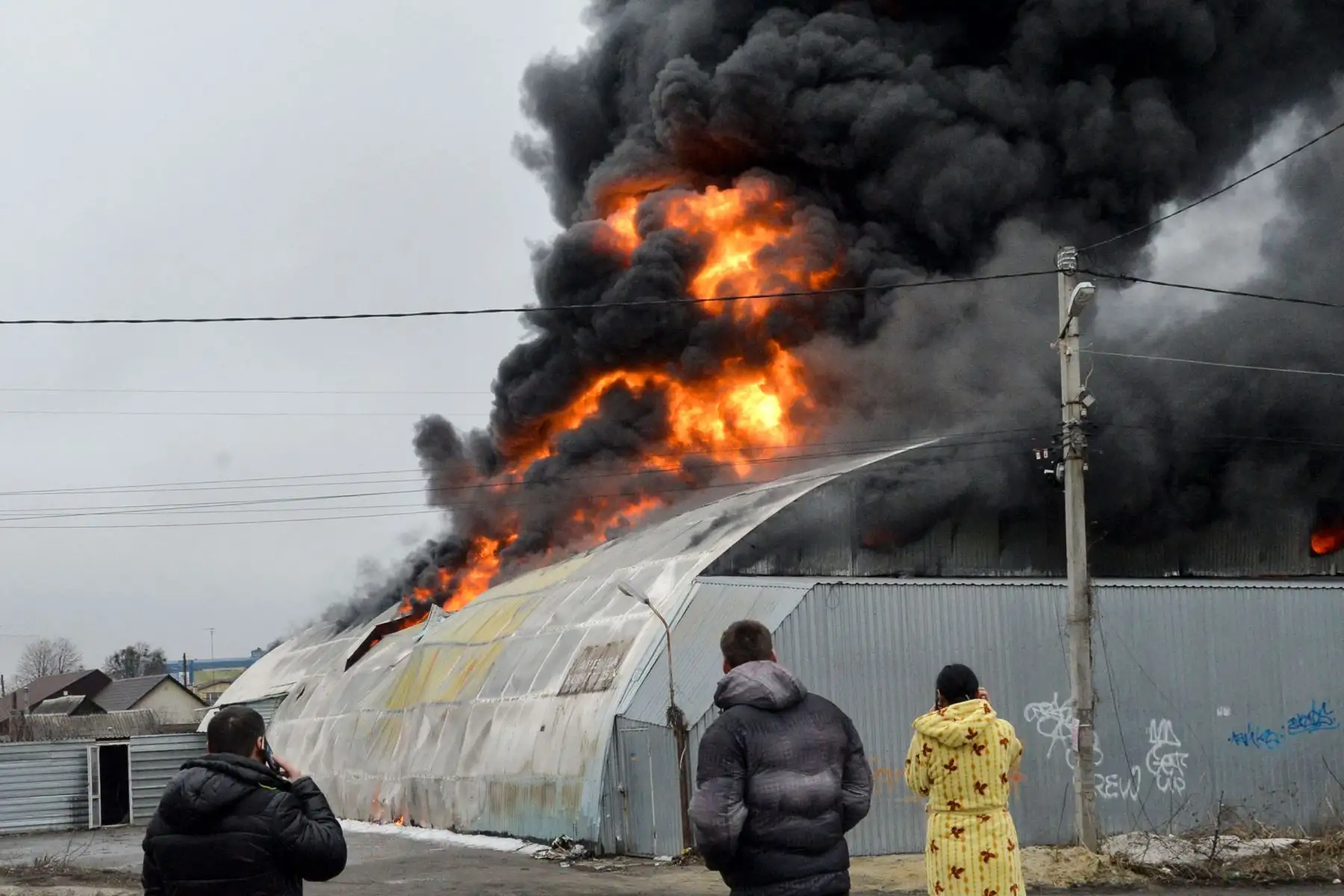 Los residentes locales reaccionan frente al edificio en llamas después de que las fuerzas rusas dijeran el bombardeo en la segunda ciudad más grande de Ucrania, Kharkiv.
Foto: AFP
