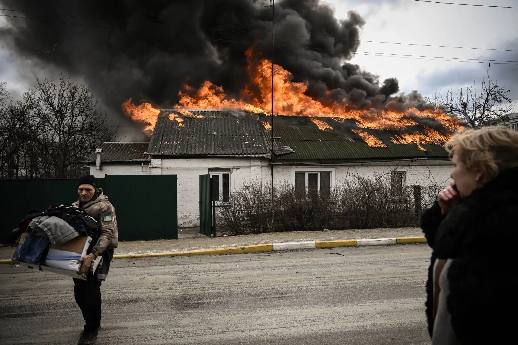 Ucranianos retiran sus pertenencias de una casa en llamas después de ser bombardeada en Kiev. Foto: AFP