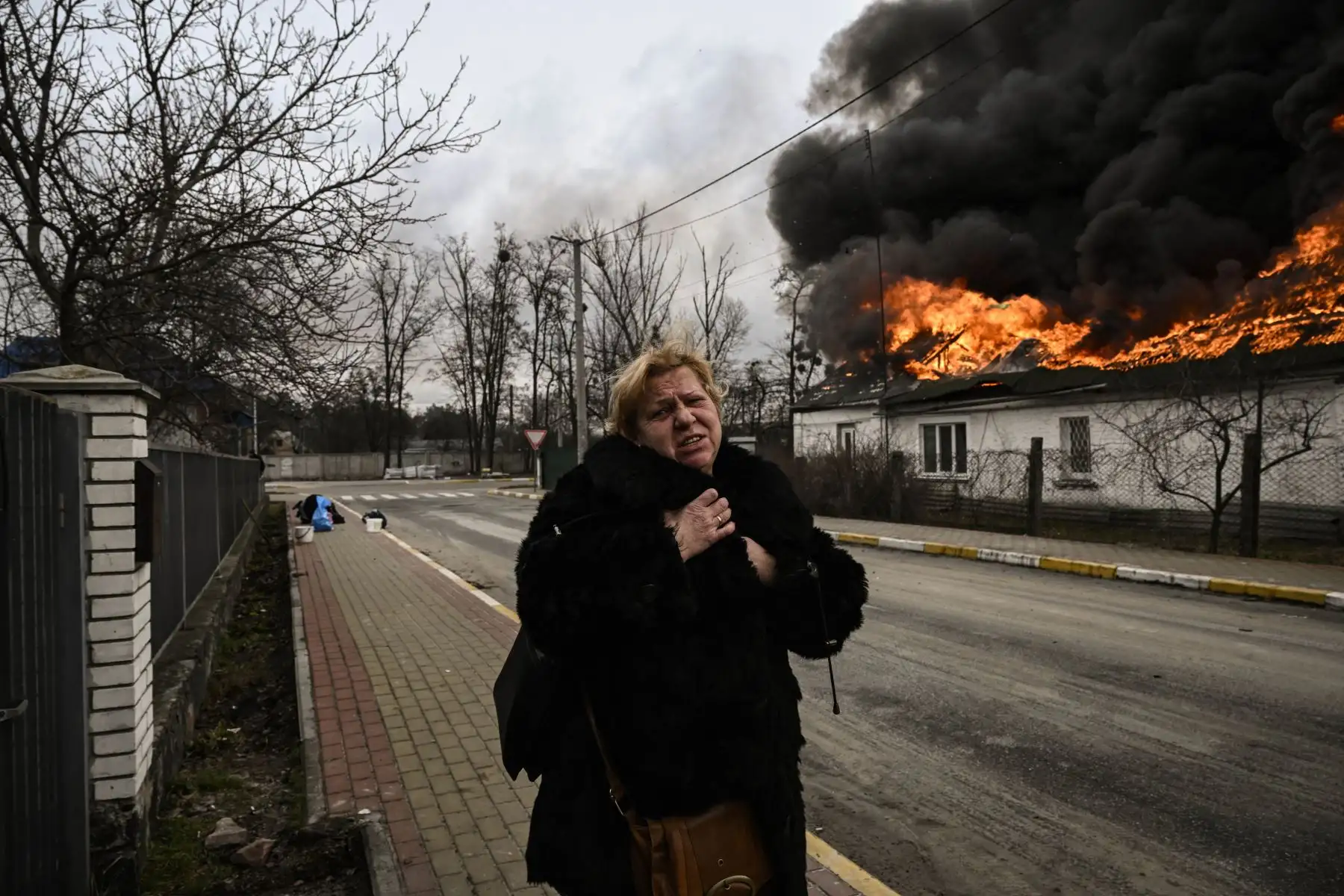 Ucranianos retiran sus pertenencias de una casa en llamas después de ser bombardeada en Kiev. Foto: AFP