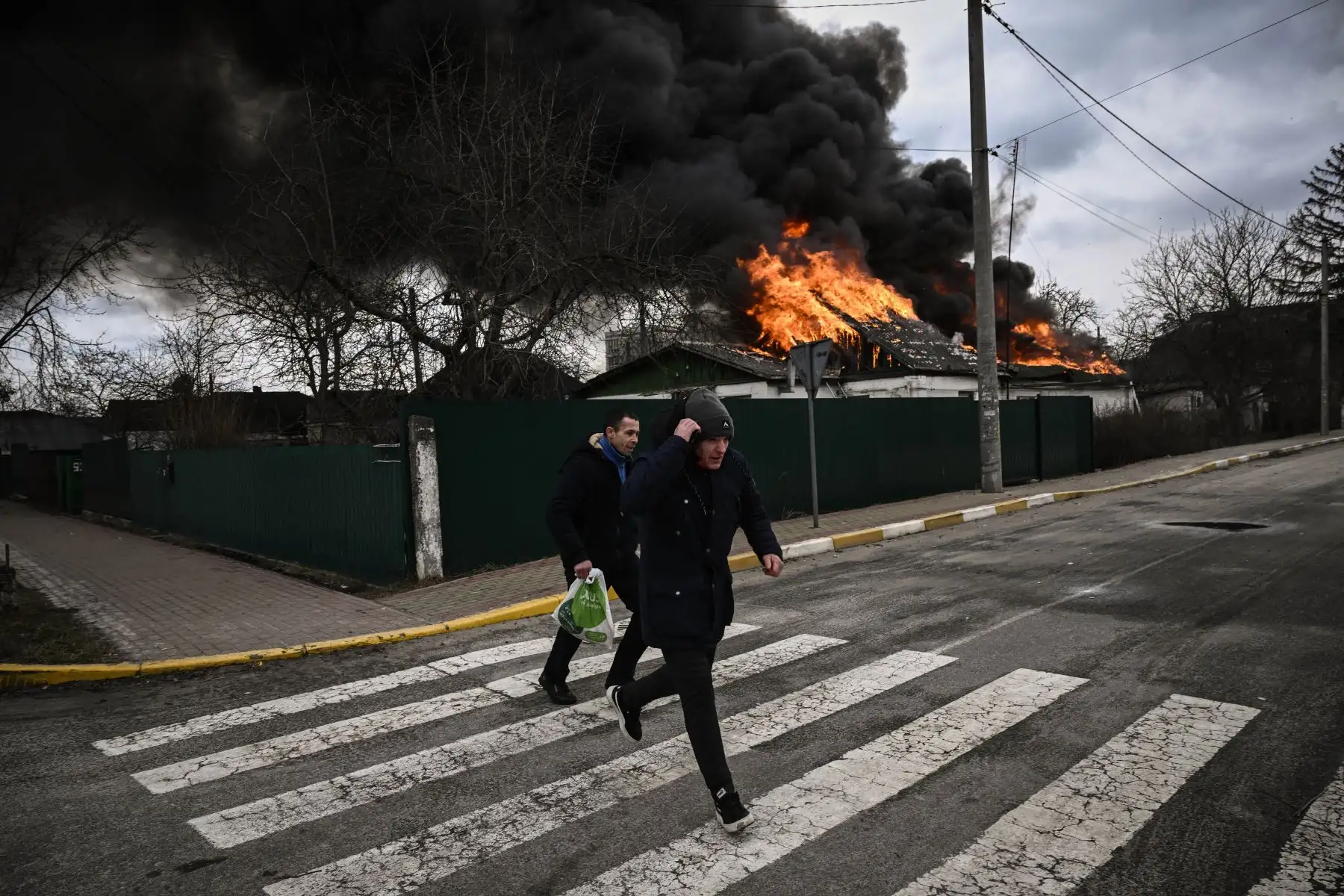 Ucranianos retiran sus pertenencias de una casa en llamas después de ser bombardeada en Kiev. Foto: AFP