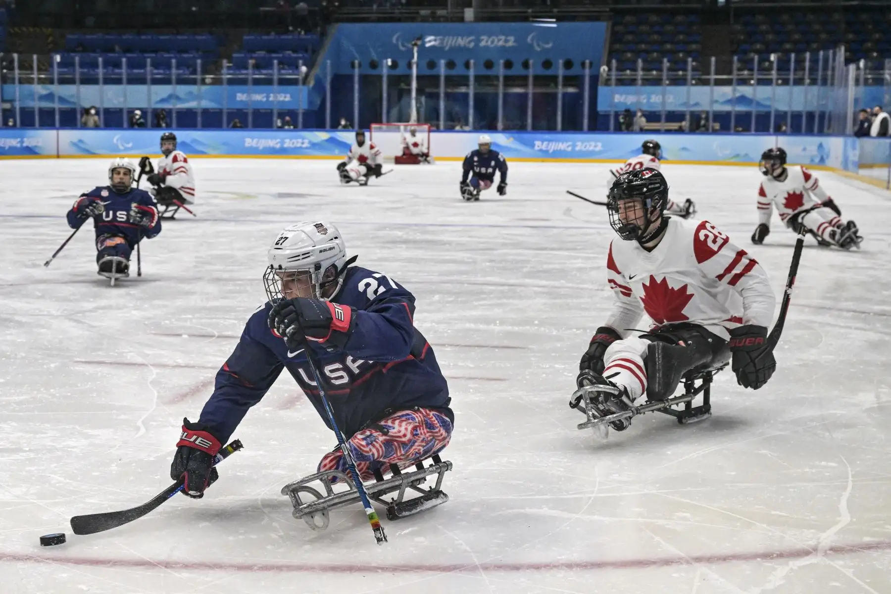 Josh Pauls de EE. UU. controla el disco contra Antoine Lehoux de Canadá en el partido de la ronda preliminar de hockey sobre hielo durante los Juegos Paralímpicos de Invierno de Beijing 2022. Foto: AFP