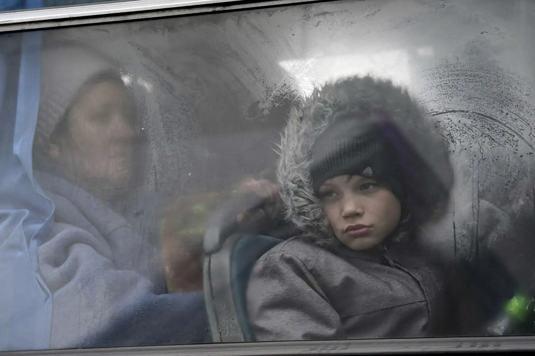 Un niño ucraniano mira por la ventana de un autobús en Korczowa, Polonia. El Alto Comisionado de Naciones Unidas para Refugiados (ACNUR) ha estimado hoy que más de 1.3 millones de refugiados ucranianos 
abandonaron el país desde el inicio de la ofensiva rusa. Foto: AFP