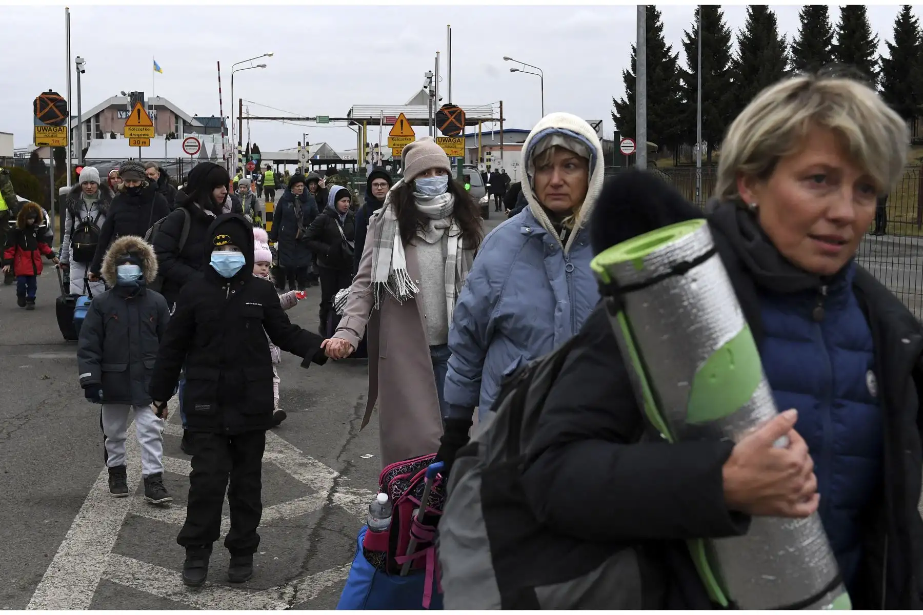 Personas que vienen de Ucrania cruzan la frontera entre Ucrania y Polonia en Korczowa, Polonia. Foto: AFP