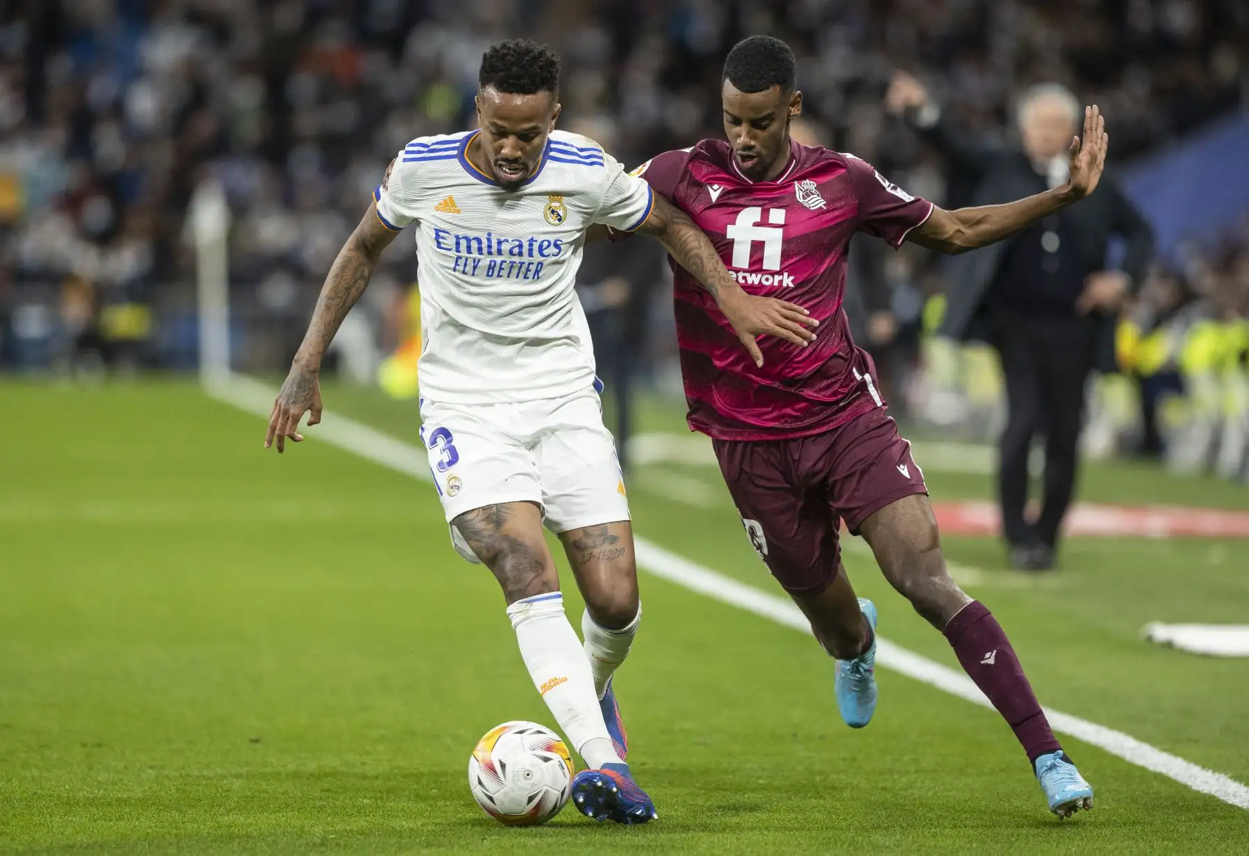 El delantero de la Real Sociedad Mikel Oyarzabal (i) controla el balón junto al brasileño Éder Militão, del Real Madrid, durante el partido de la jornada 27 de LaLiga que Real Madrid y Real Sociedad disputan hoy sábado en el estadio Santiago Bernabéu, en Madrid. EFE/Rodrigo Jiménez