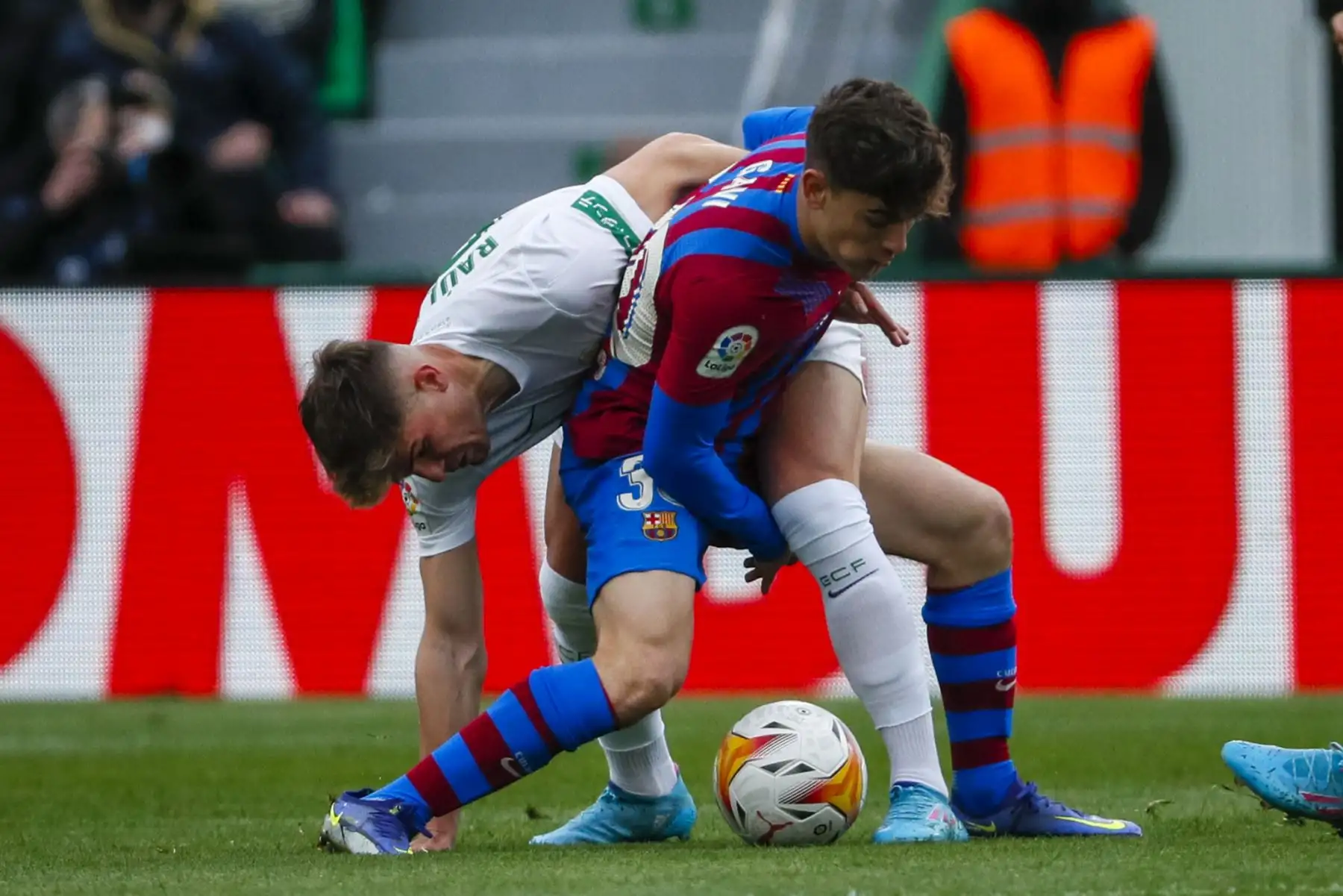 El centrocampista del Elche, Raúl Guti y el delantero del FC Barcelona, Pablo Martín "Gavi" , en acción durante el partido de la Liga, en el estadio Martínez Valero en Elche. Foto: EFE