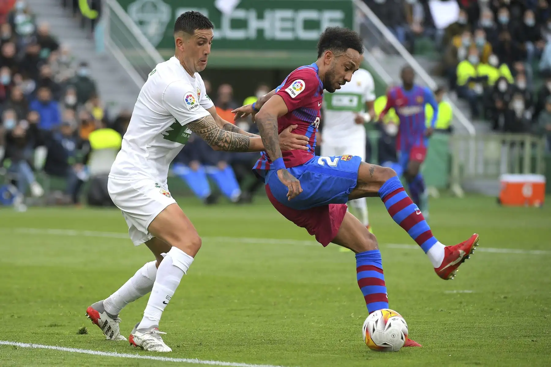 El defensa chileno de Elche, Enzo Roco, desafía al centrocampista gabonés de Barcelona, Pierre-Emerick Aubameyang, durante el partido de la liga española, en el estadio Martínez Valero. Foto: AFP