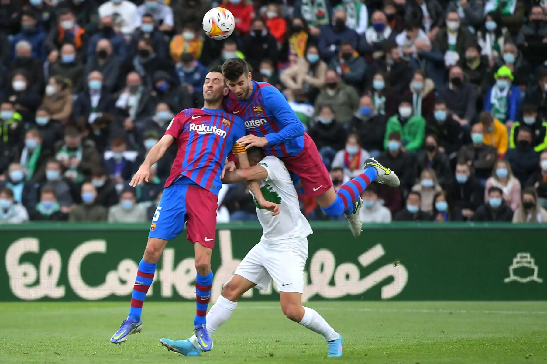 El delantero argentino del Elche Lucas Boye compite con el centrocampista español Sergio Busquets y defensa Gerard Piqué del Barcelona durante el partido de la liga española, en el estadio Martínez Valero. Foto: AFP