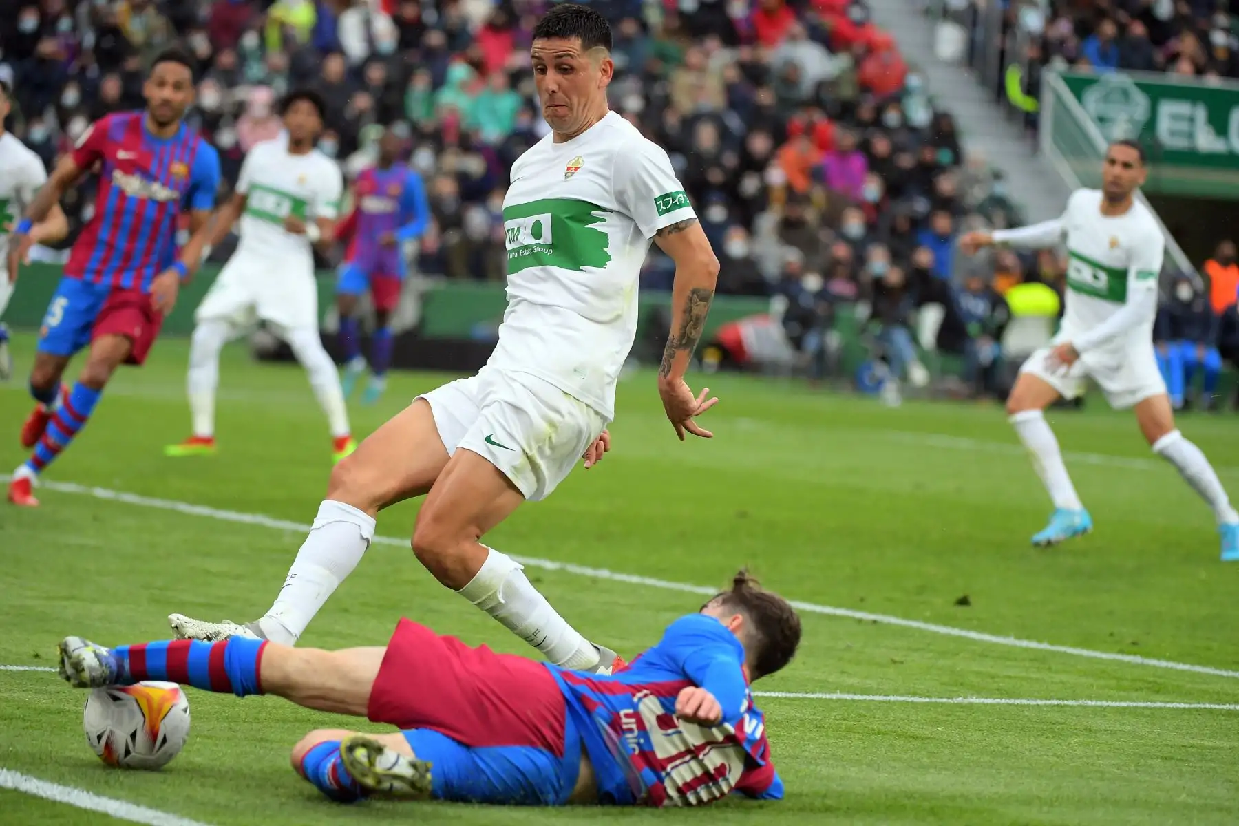 El defensa chileno del Elche, Enzo Roco, compite con el mediocampista español del Barcelona, Gavi, durante el partido de la liga española. Foto: AFP