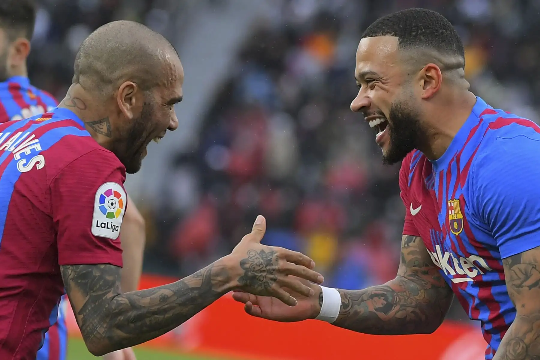 El delantero holandés de Barcelona, Memphis Depay, celebra con su compañero Dani Alves tras marcar el segundo gol contra el Elche durante el partido de la liga española, en el estadio Martínez Valero. Foto: AFP