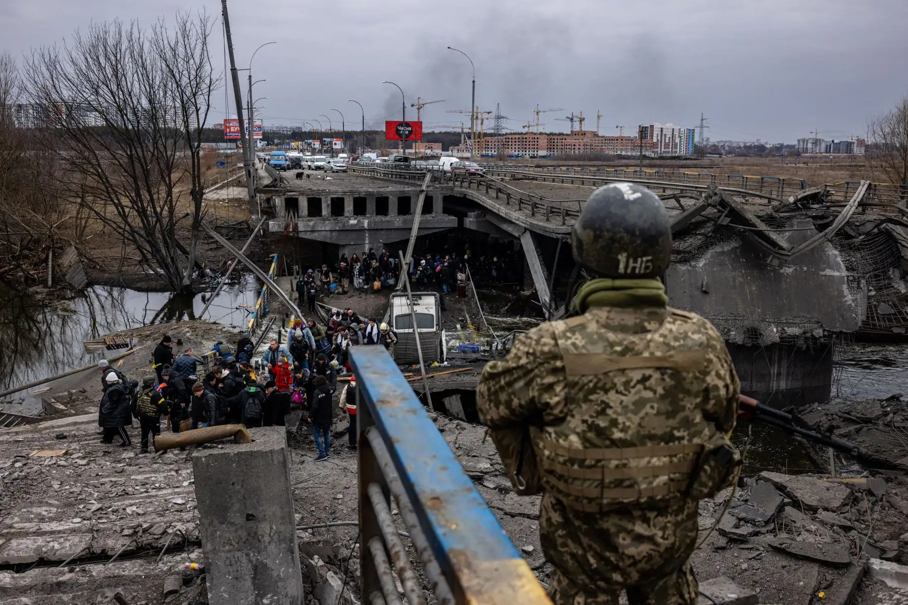 Ucranianos  evacuados  caminan a lo largo de la orilla del río cerca de un puente destruido mientras huyen de la ciudad de Irpin, al noroeste de Kiev.
Foto: AFP