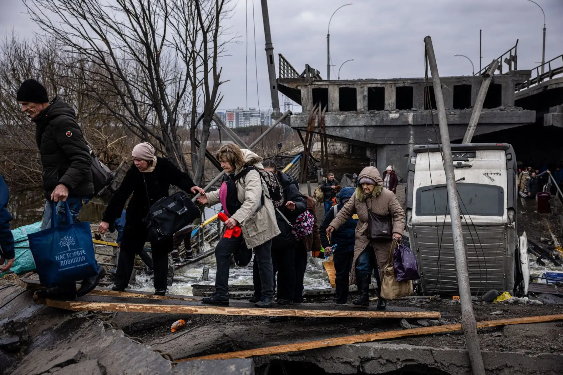 Ucranianos evacuados cruzan un puente destruido mientras huyen de la ciudad de Irpin, al noroeste de Kiev.
Foto: AFP