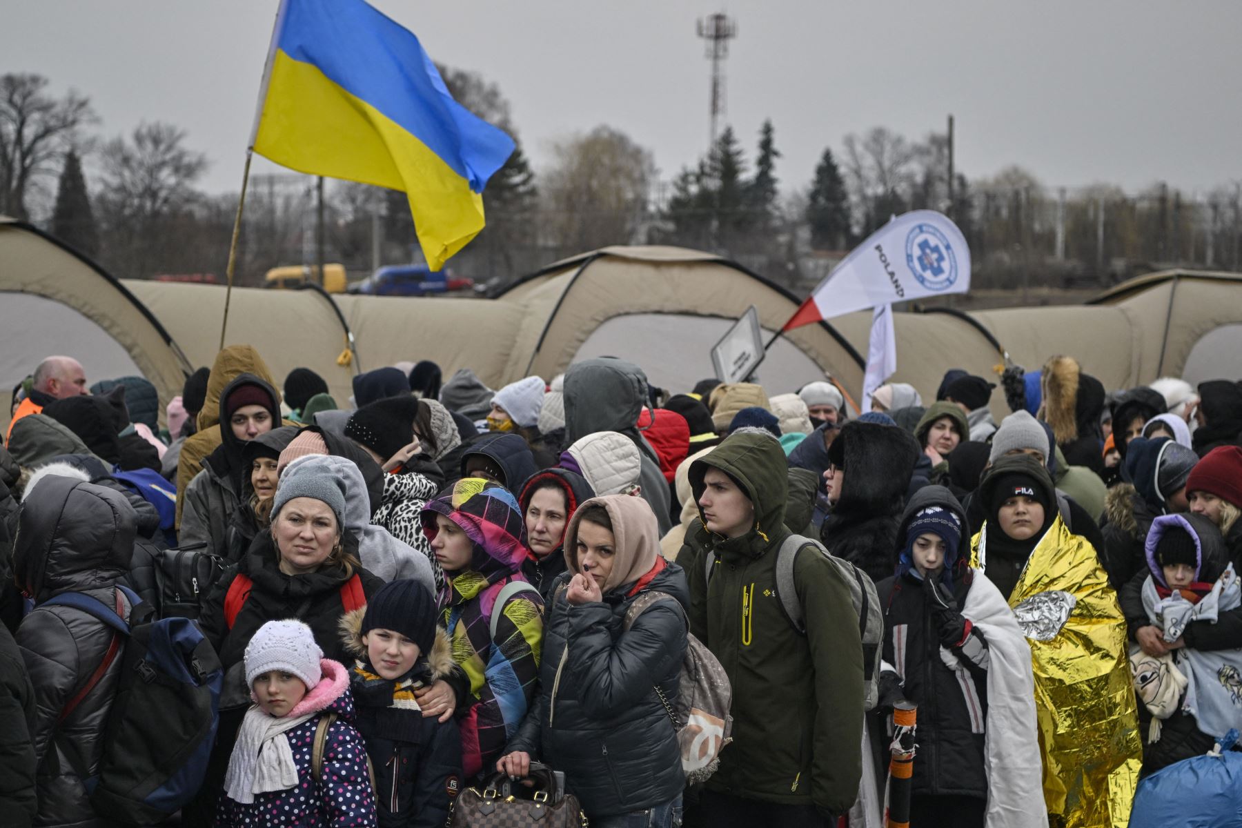 Cientos de refugiados hacen fila mientras esperan ser trasladados después de cruzar la frontera de Ucrania hacia Polonia, en el cruce fronterizo polaco de Medyka. Foto: AFP