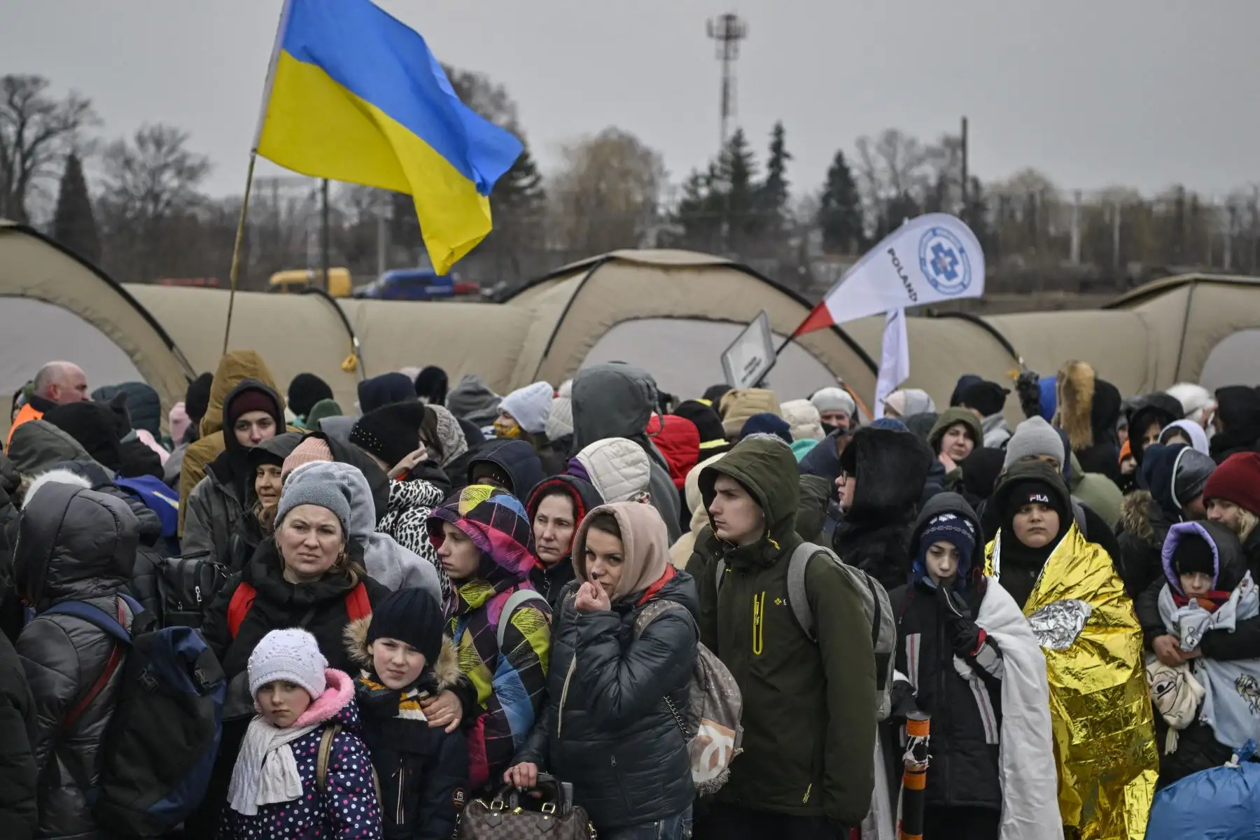 Cientos de refugiados hacen fila mientras esperan ser trasladados después de cruzar la frontera de Ucrania hacia Polonia, en el cruce fronterizo de Medyka en Polonia.
Foto: AFP