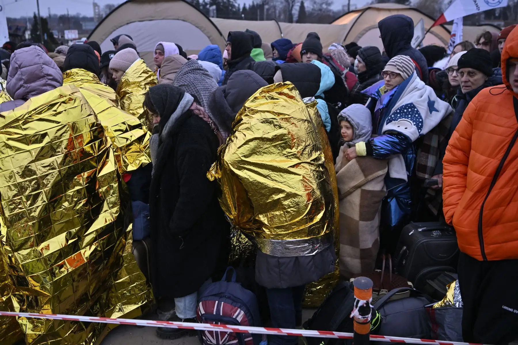Las personas se detienen en temperaturas heladas mientras esperan ser trasladadas a una estación de tren, después de cruzar las fronteras de Ucrania hacia Polonia, en el cruce fronterizo de Medyka en Polonia.
Foto: AFP