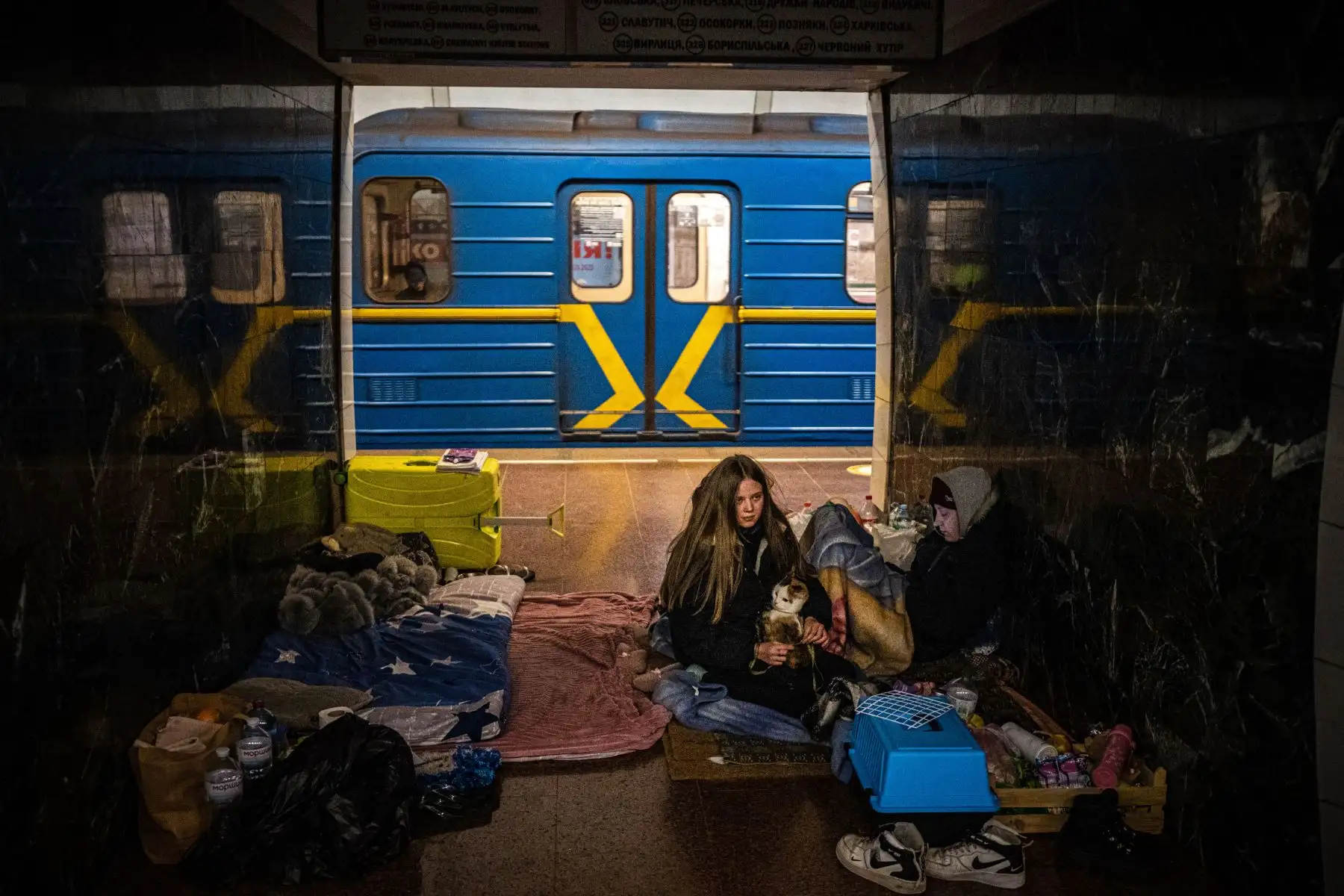 Una mujer abraza a su gato dentro de un vagón de metro en una estación subterránea utilizada como refugio antiaéreo en Kiev.
Foto: AFP