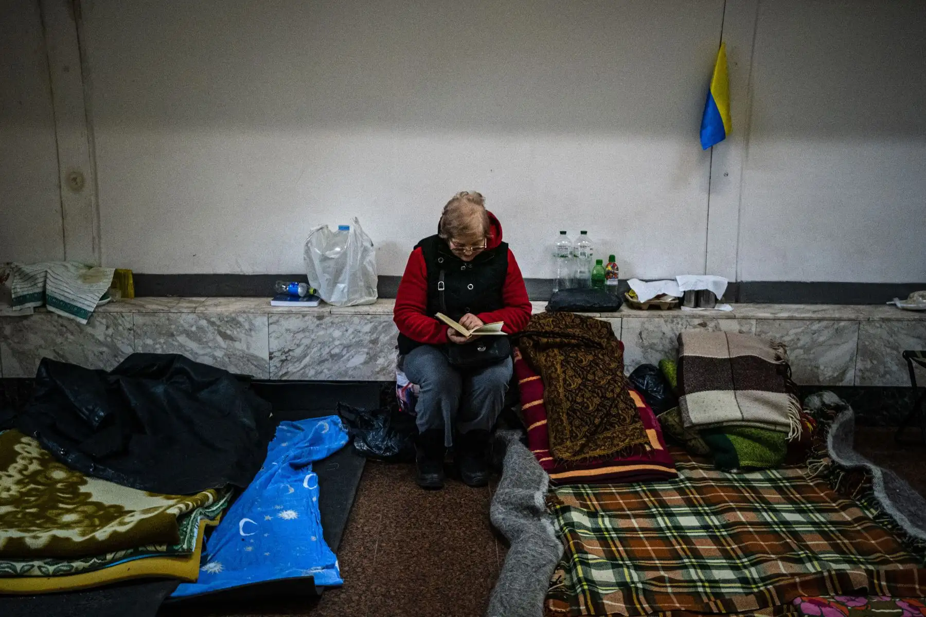 Una mujer lee un libro dentro de un vagón de metro en una estación subterránea utilizada como refugio antiaéreo en Kiev.
Foto: AFP