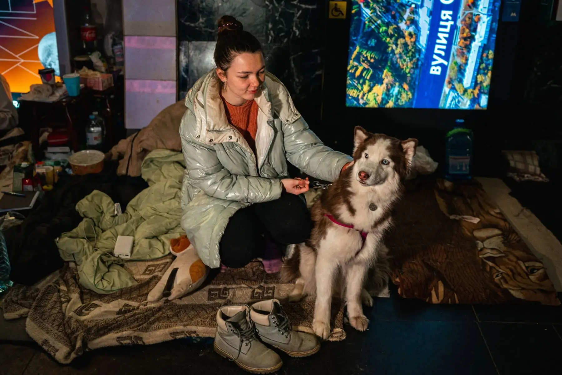 Tania Boyko, de 20 años, y su perro Kari se sientan en una cama improvisada en una estación de metro subterránea utilizada como refugio antiaéreo en Kiev.
Foto: AFP