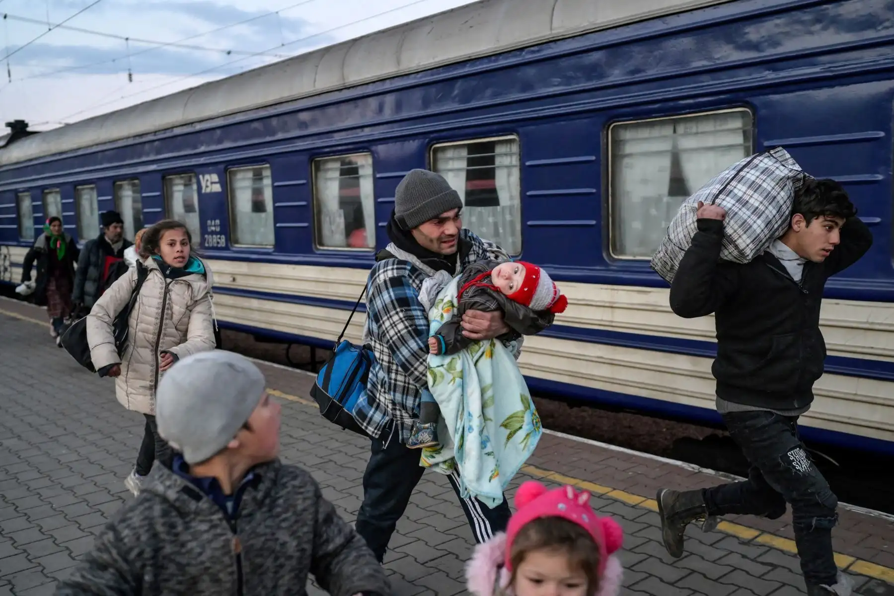 La gente se apresura a tomar un tren y evacuar la ciudad en la estación central de trenes de la principal ciudad portuaria de Odessa, que permanece bajo control ucraniano. Foto: AFP