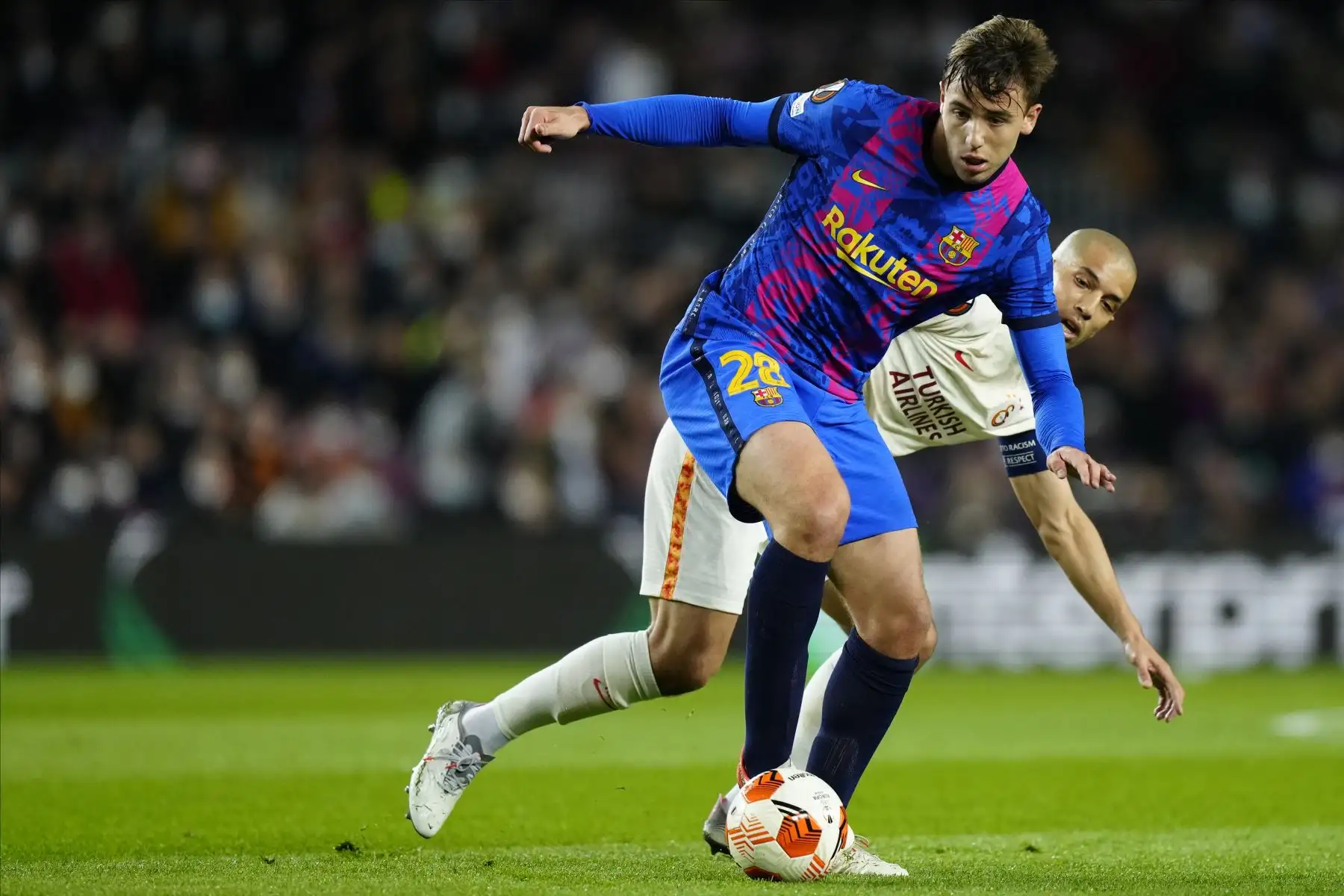 El centrocampista del FC Barcelona, Nico González disputa el balón ante  el delantero neerlandés del Galatasaray, Ryan Babel, durante el encuentro correspondiente a la ida de los octavos de final de la Liga Europa disputado hoy en el estadio del Camp Nou, en Barcelona. 
Foto: EFE