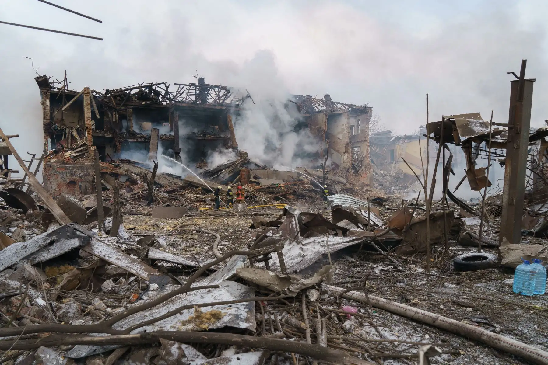 Los bomberos rocían agua en una fábrica de calzado destruida luego de un ataque aéreo en Dnipro. Foto: AFP