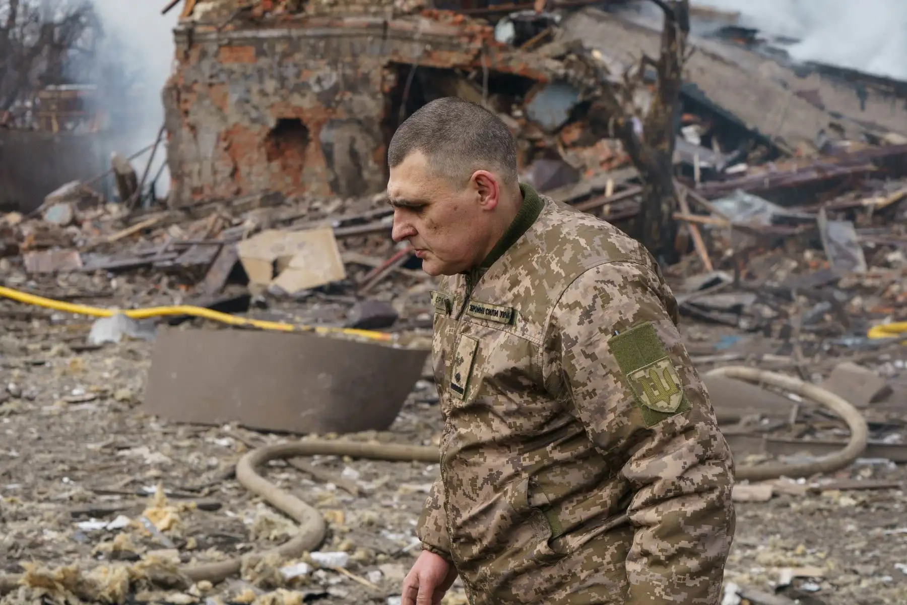 El oficial de asuntos públicos del ejército de Ucrania, Valentin Yermolenko, camina frente a una fábrica de zapatos destruida luego de un ataque aéreo en Dnipro. Foto: AFP