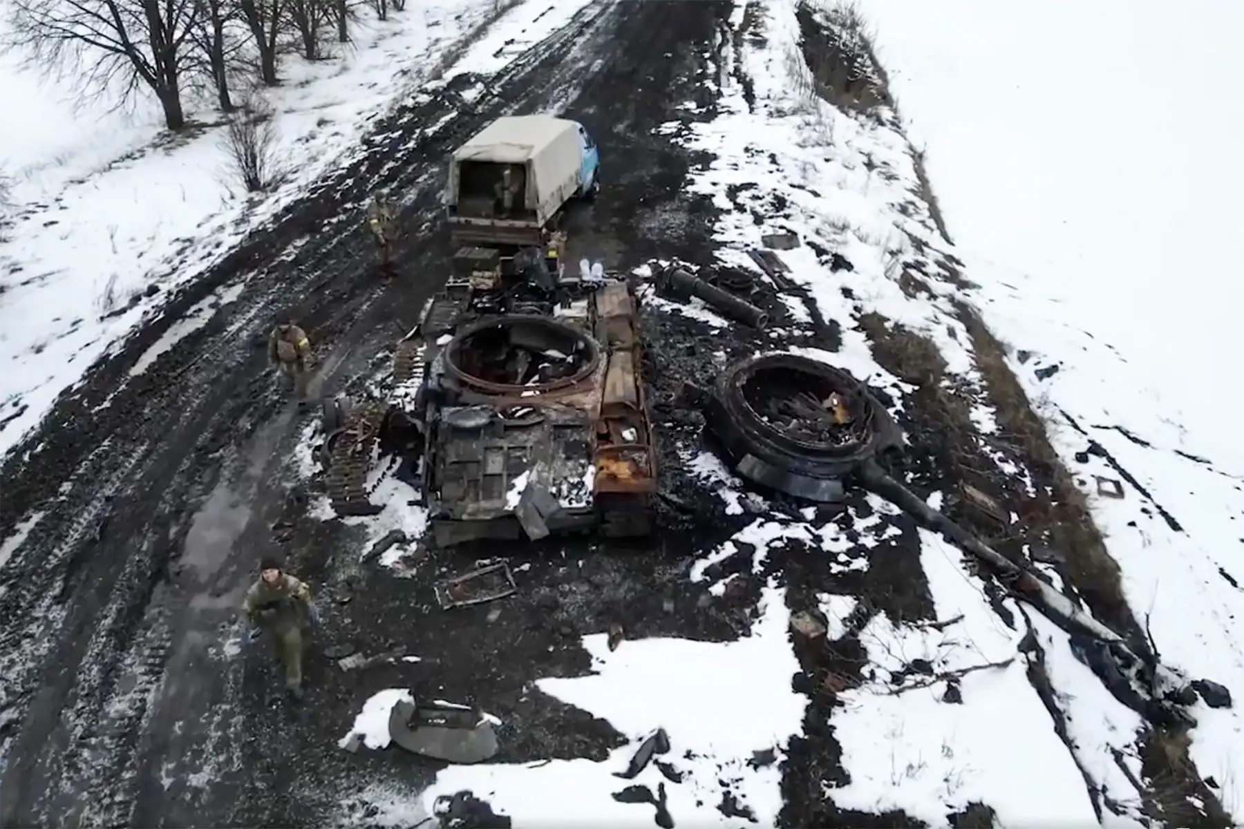 Militares ucranianos recolectando municiones capturadas cerca de un tanque dañado. Foto: AFP