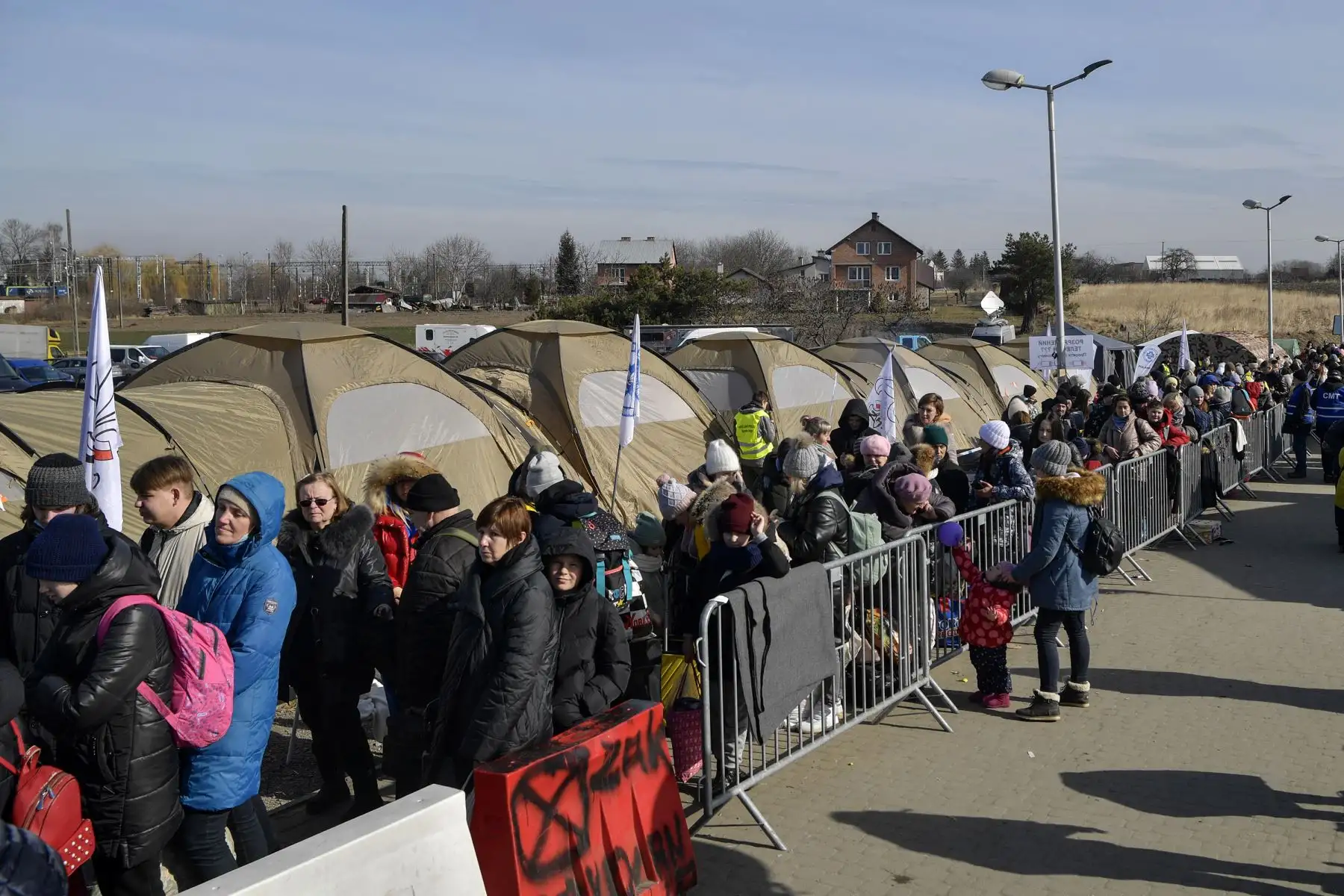 Los refugiados hacen cola mientras esperan más transporte en el cruce fronterizo de Medyka, después de cruzar en la frontera entre Ucrania y Polonia. Foto: AFP