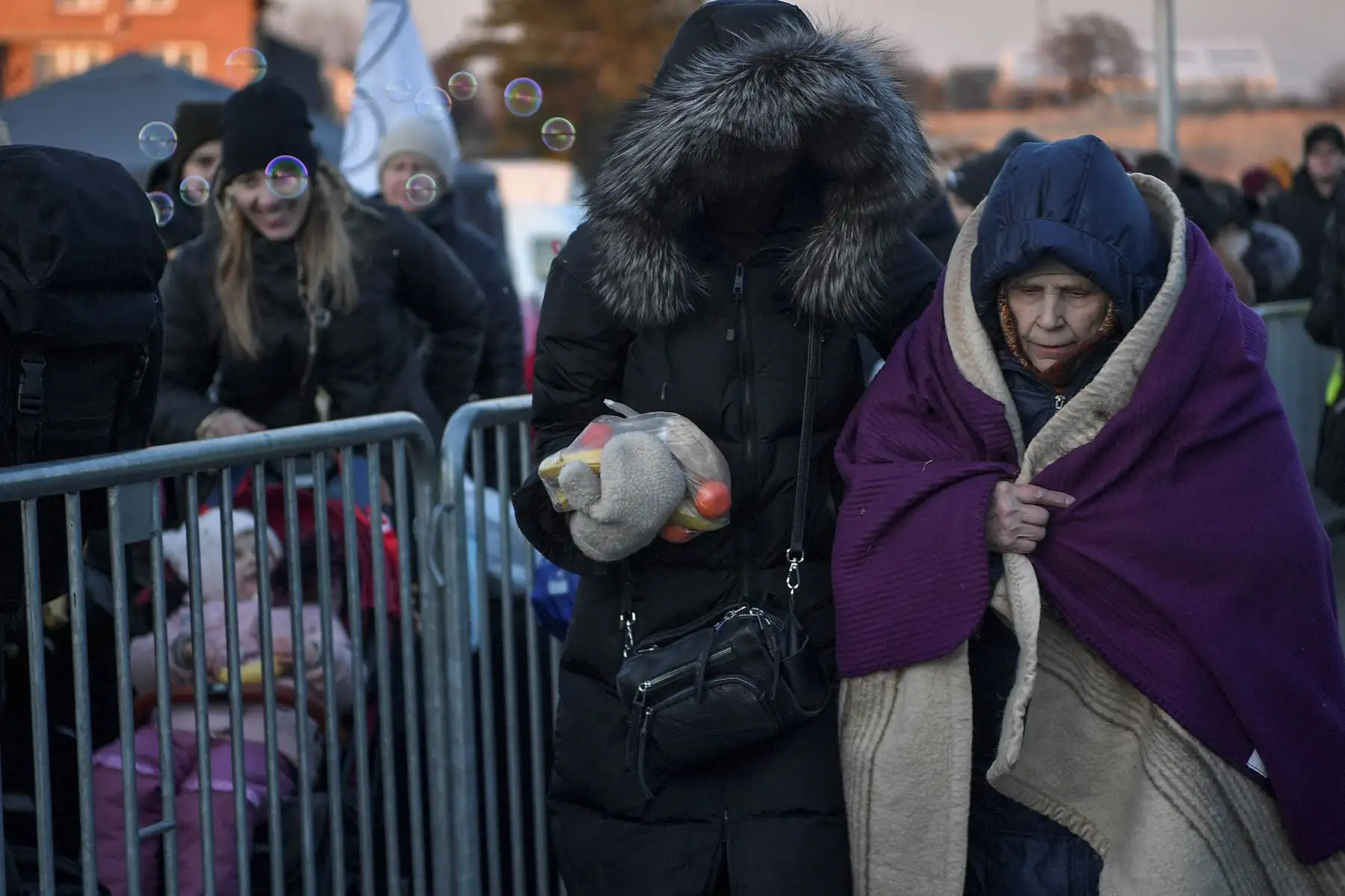 Una anciana recibe ayuda y alimentos después de cruzar la frontera de Ucrania con Polonia. Foto: AFP