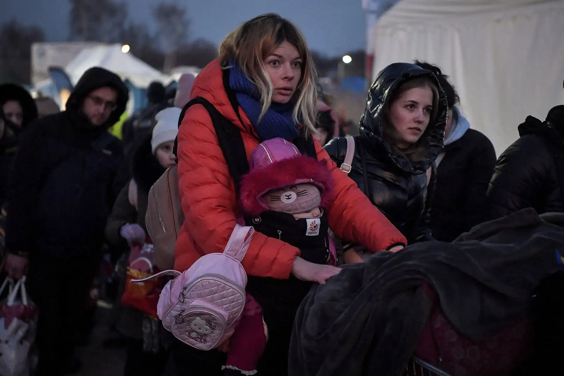 Una madre junto a sus hijos llegan al campo de Medyka después de cruzar la frontera de Ucrania con Polonia. Foto: AFP