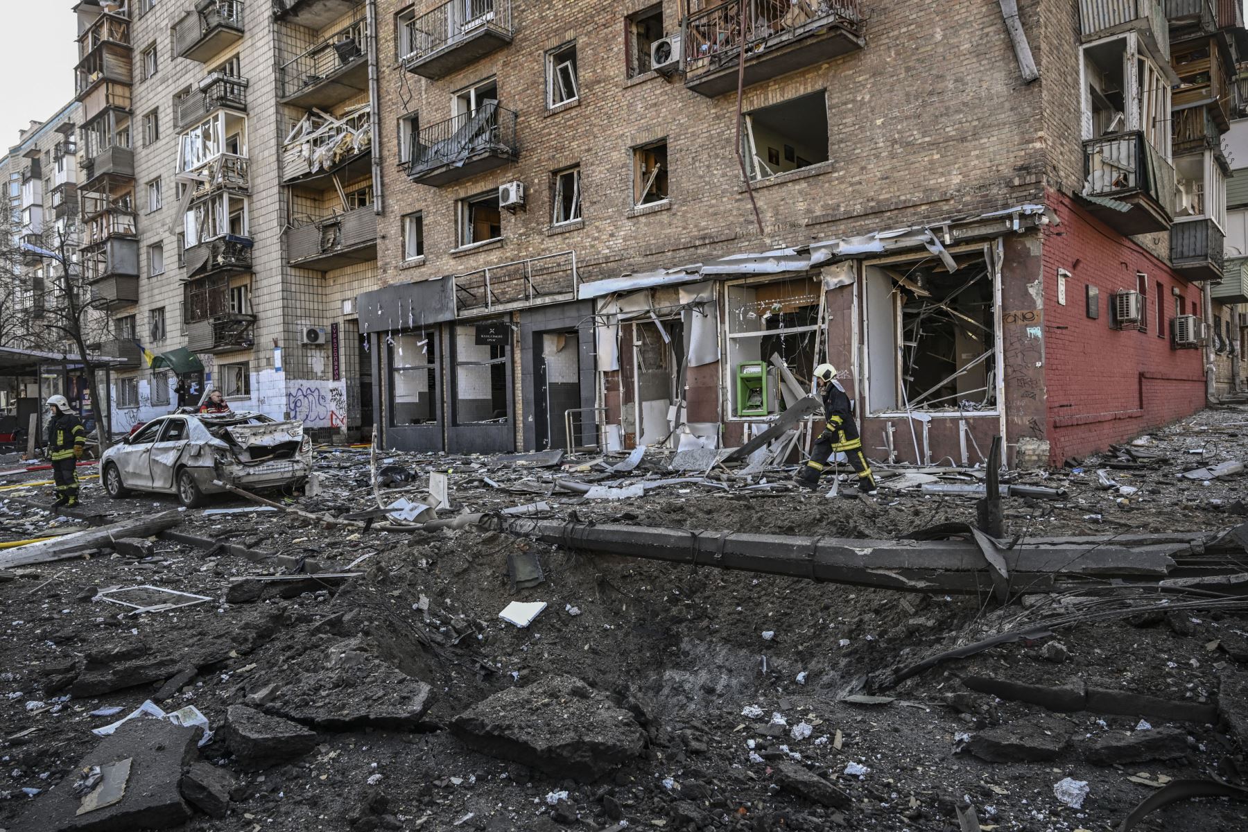Un bombero camina entre un cráter y un edificio de apartamentos destruido luego de un bombardeo en el distrito noroccidental de Obolon en Kiev.
Foto: AFP