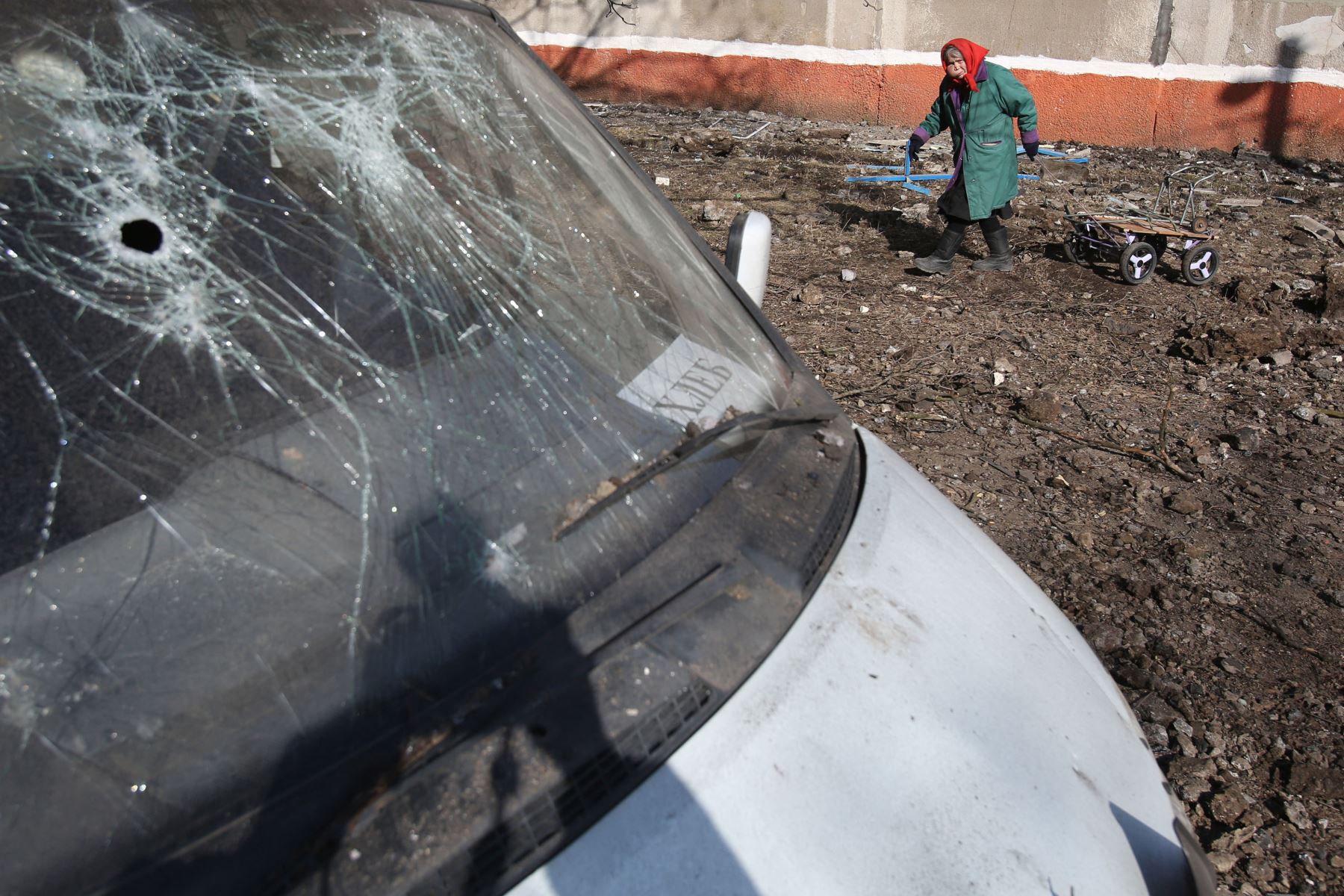 Una anciana camina cerca a un carro en una zona residencial dañada en lo que se dice fue una explosión de un misil balístico en Kramatorsk.
Foto: AFP