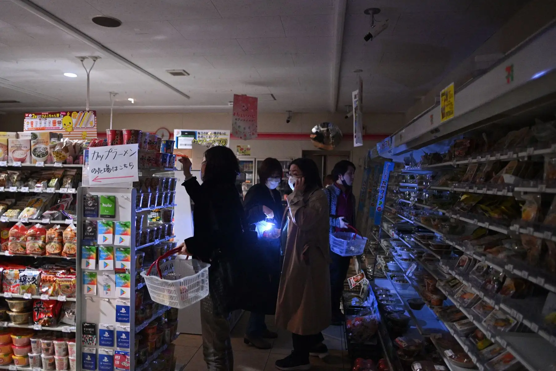 La gente compra en una tienda en un área residencial durante un corte de energía en el distrito de Koto, luego de que un poderoso terremoto de magnitud 7.3 sacudiera el este de Japón.
Foto: AFP