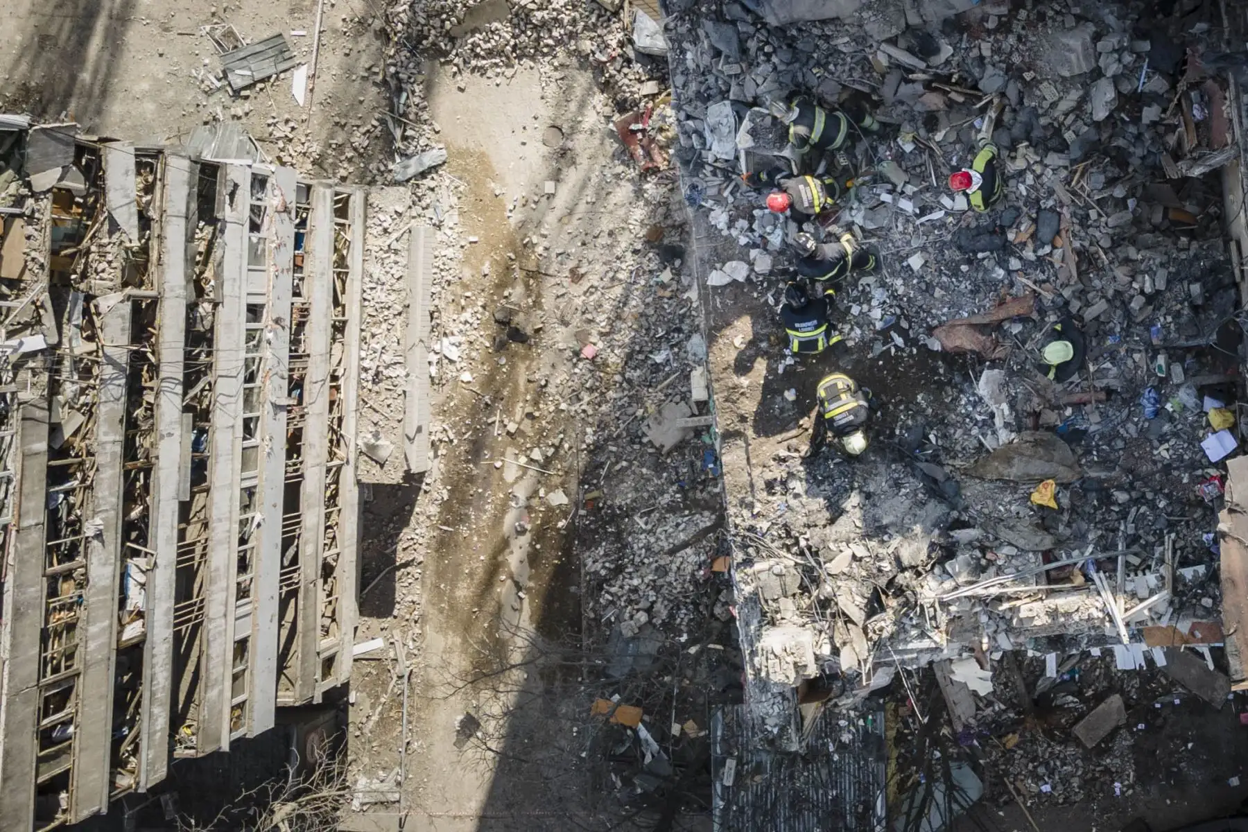 Vista aérea muestra a los bomberos trabajando entre los escombros de un edificio residencial que fue alcanzado por los escombros de un cohete derribado en Kiev. Foto: AFP